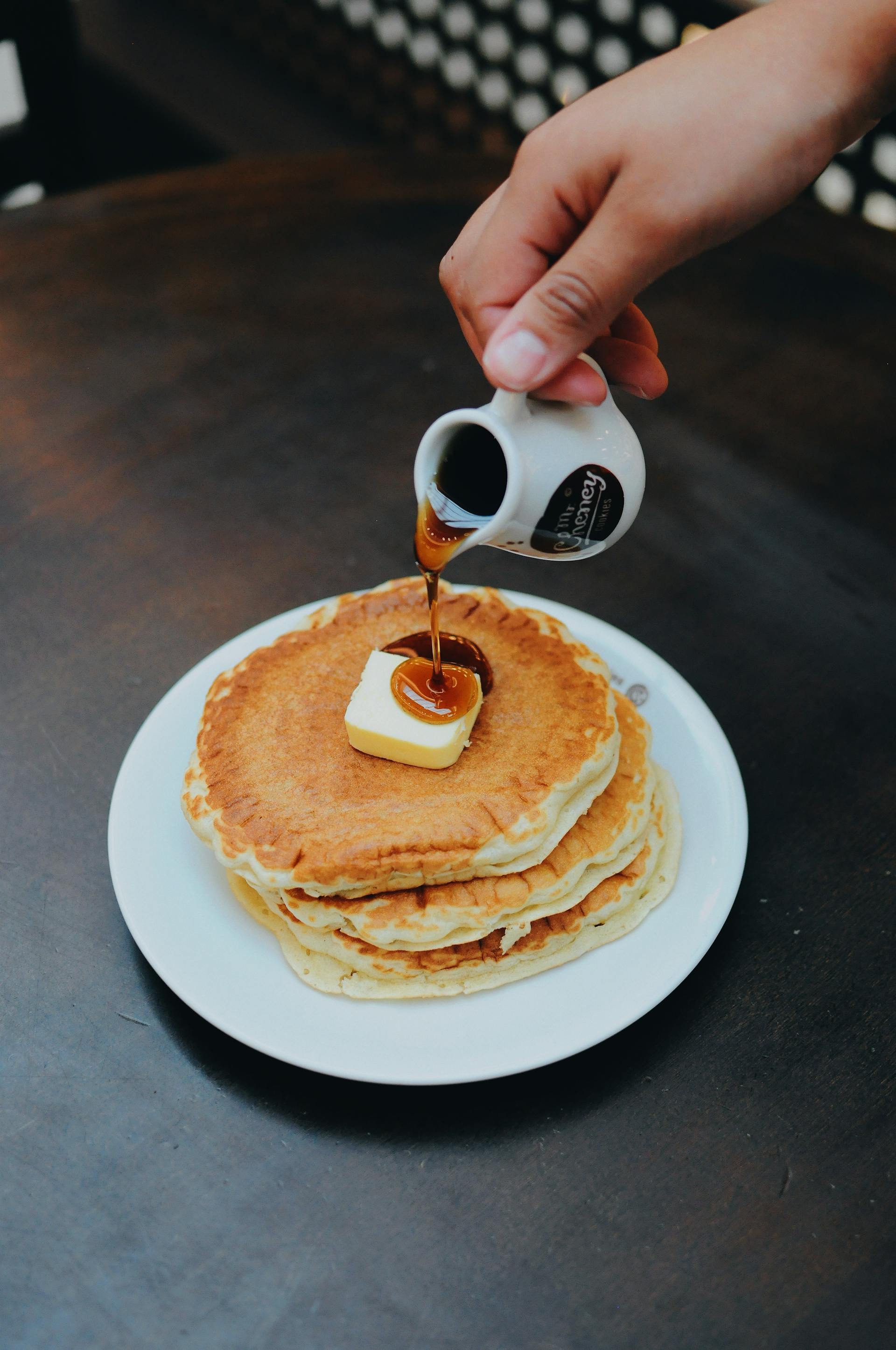 Une personne versant du sirop sur des crêpes | Source : Pexels