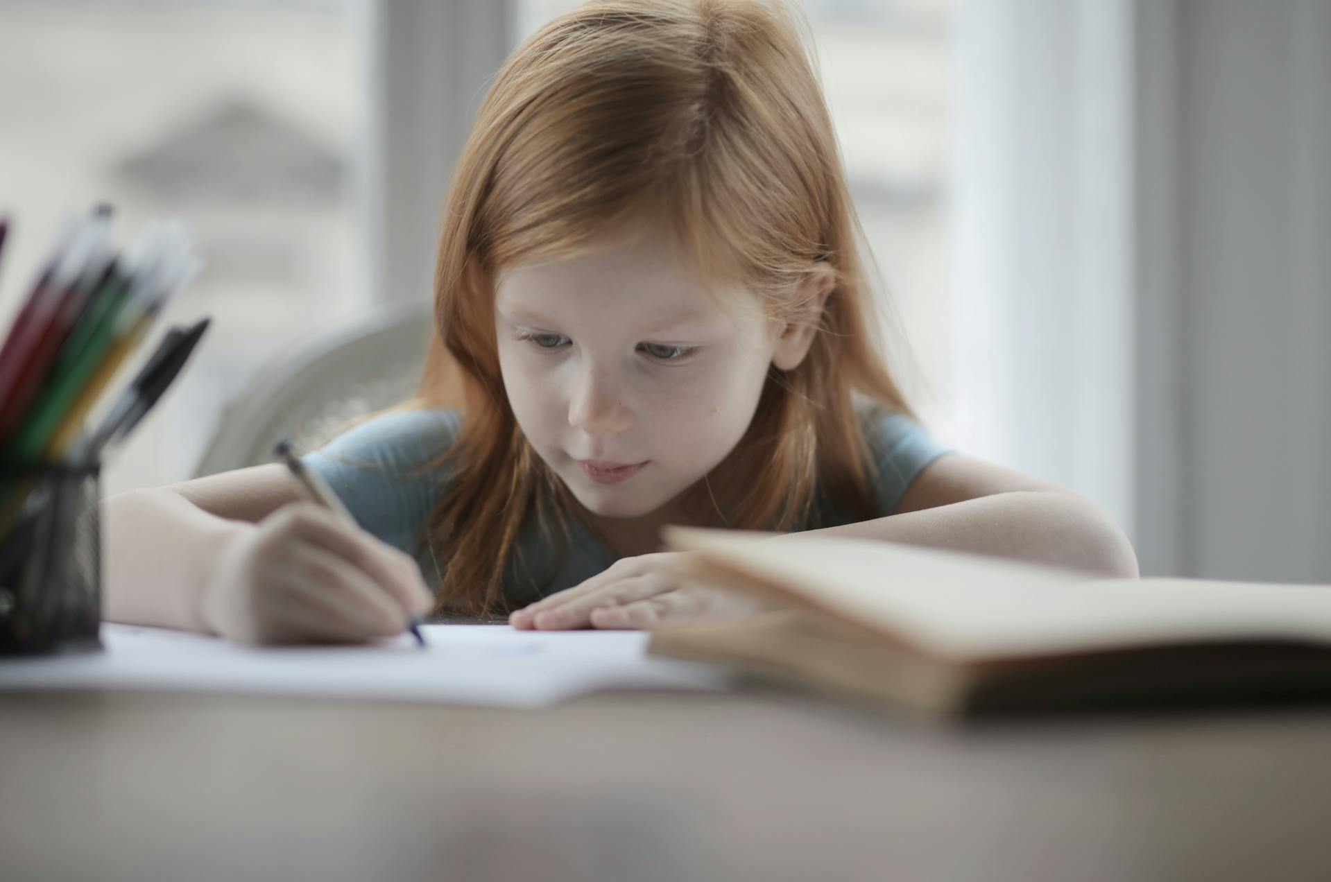 Une petite fille qui dessine quelque chose sur un morceau de papier | Source : Pexels