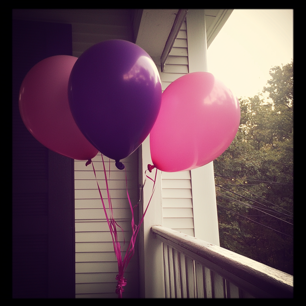 Ballons roses et violets sur un porche | Source : Midjourney