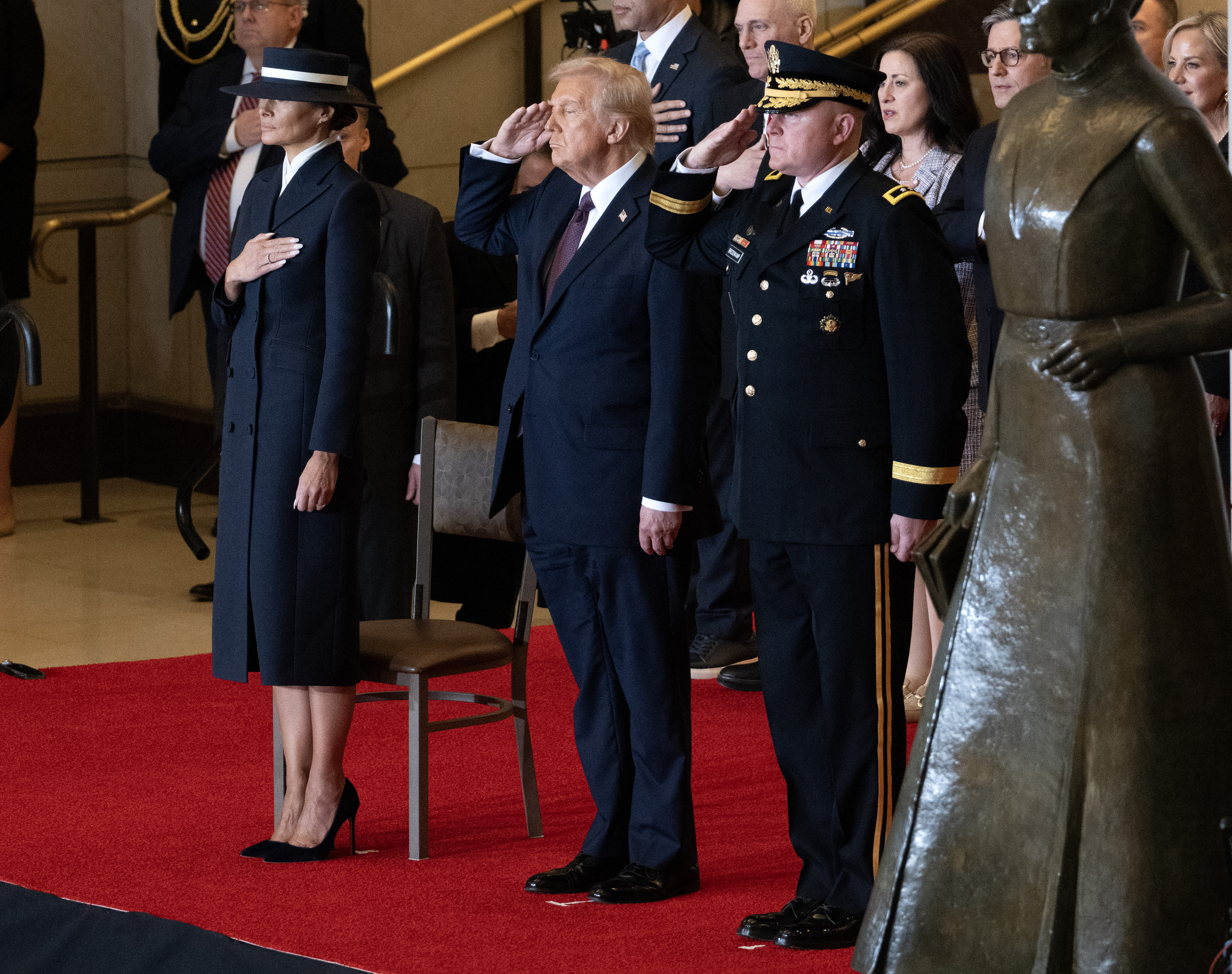 Melania Trump, la main sur la poitrine, et Donald Trump saluant lors de la cérémonie de revue des troupes. | Source : Getty Images