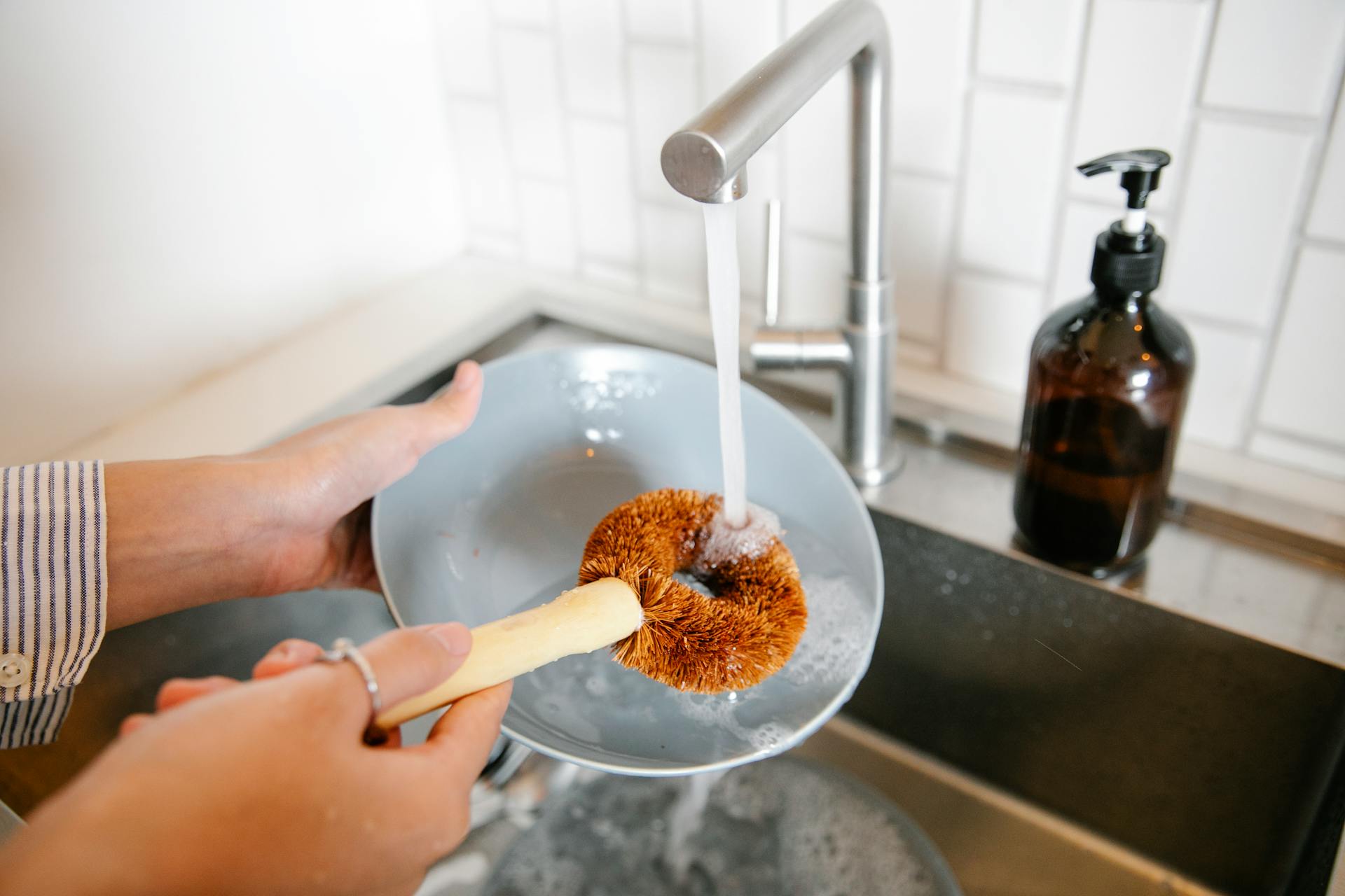 Gros plan d'une femme faisant la vaisselle dans la cuisine | Source : Pexels