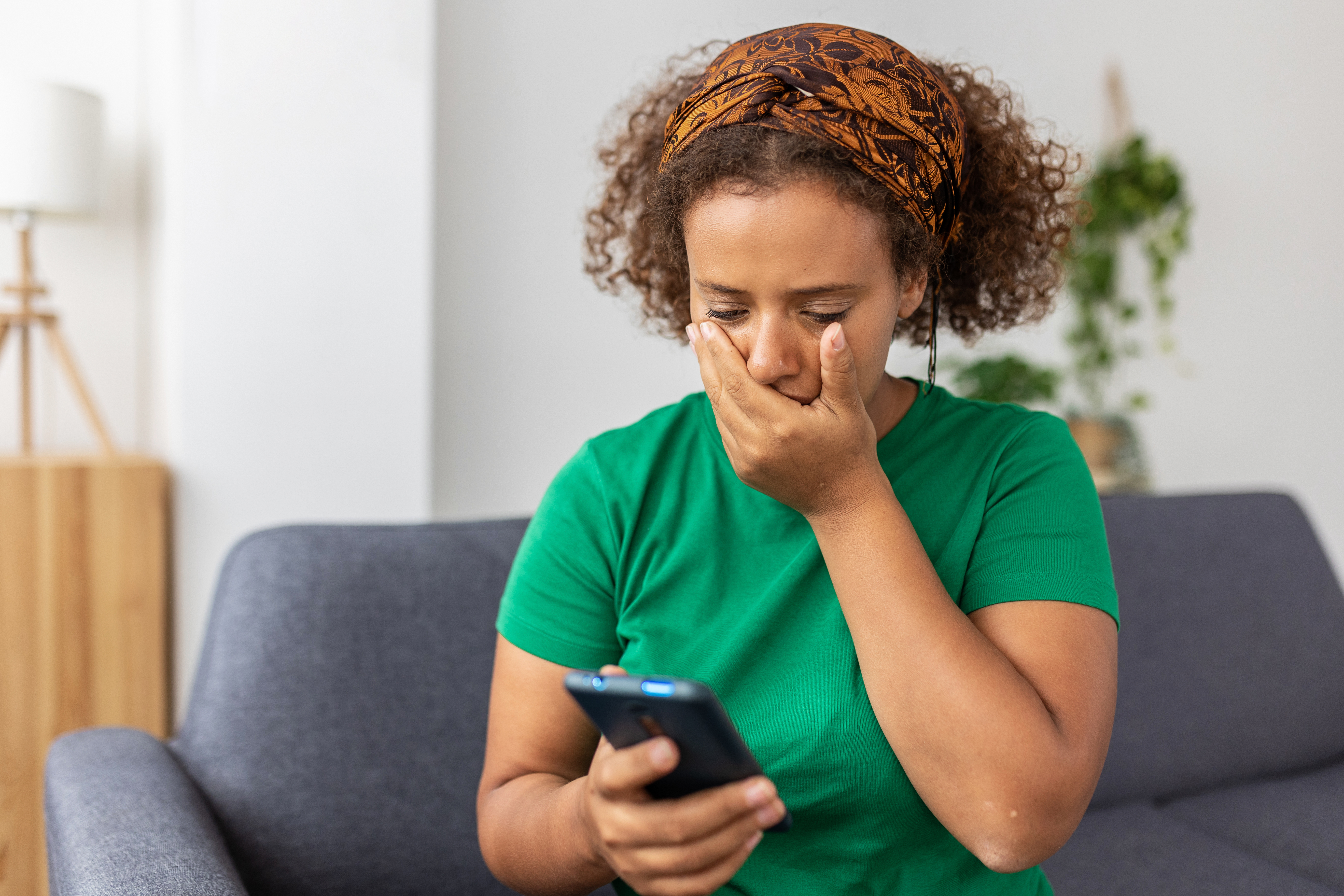 Femme désemparée regardant son téléphone avec incrédulité | Source : Getty Images