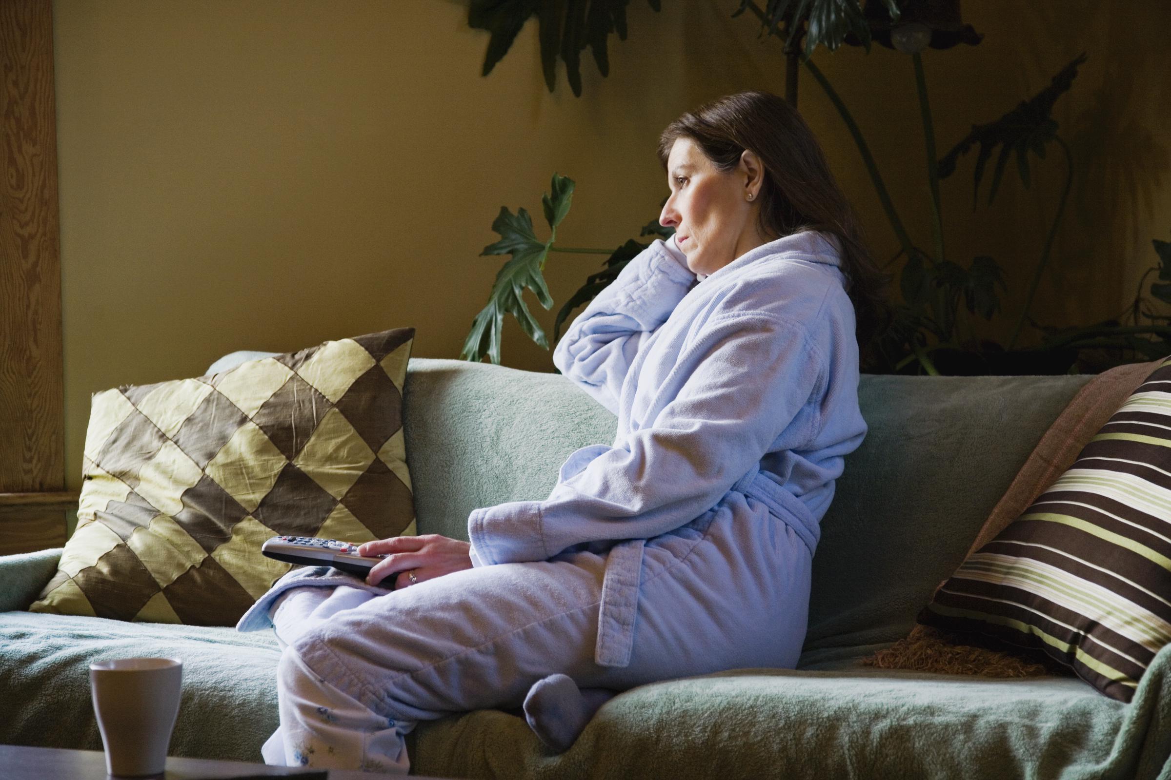 Une femme qui regarde la télévision seule en pyjama | Source : Getty Images