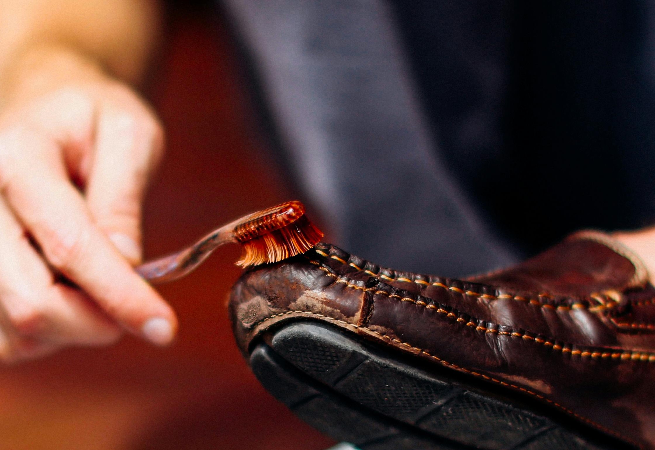 Une personne brossant une chaussure marron | Source : Pexels