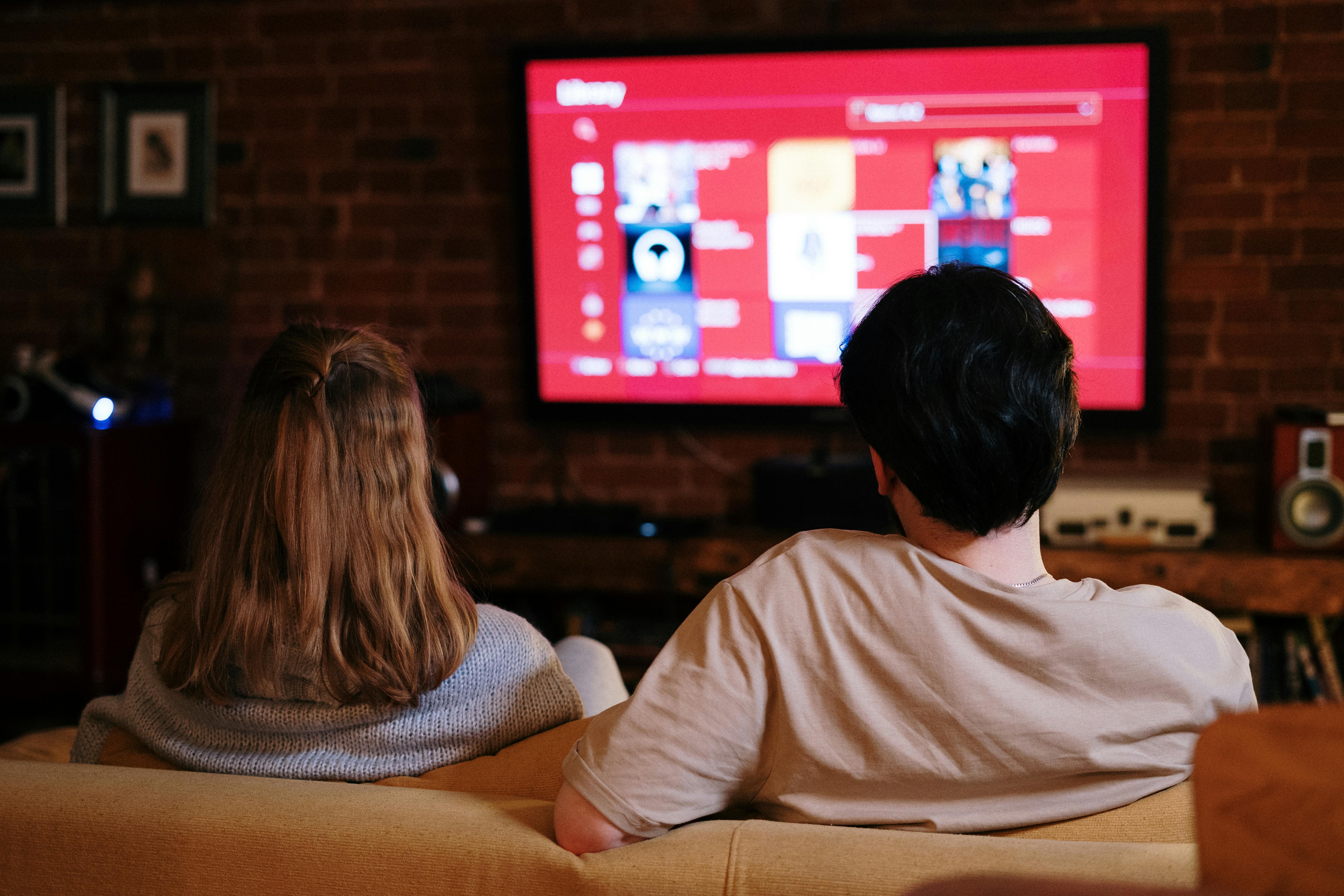 Un couple heureux regarde la télévision | Source : Pexels