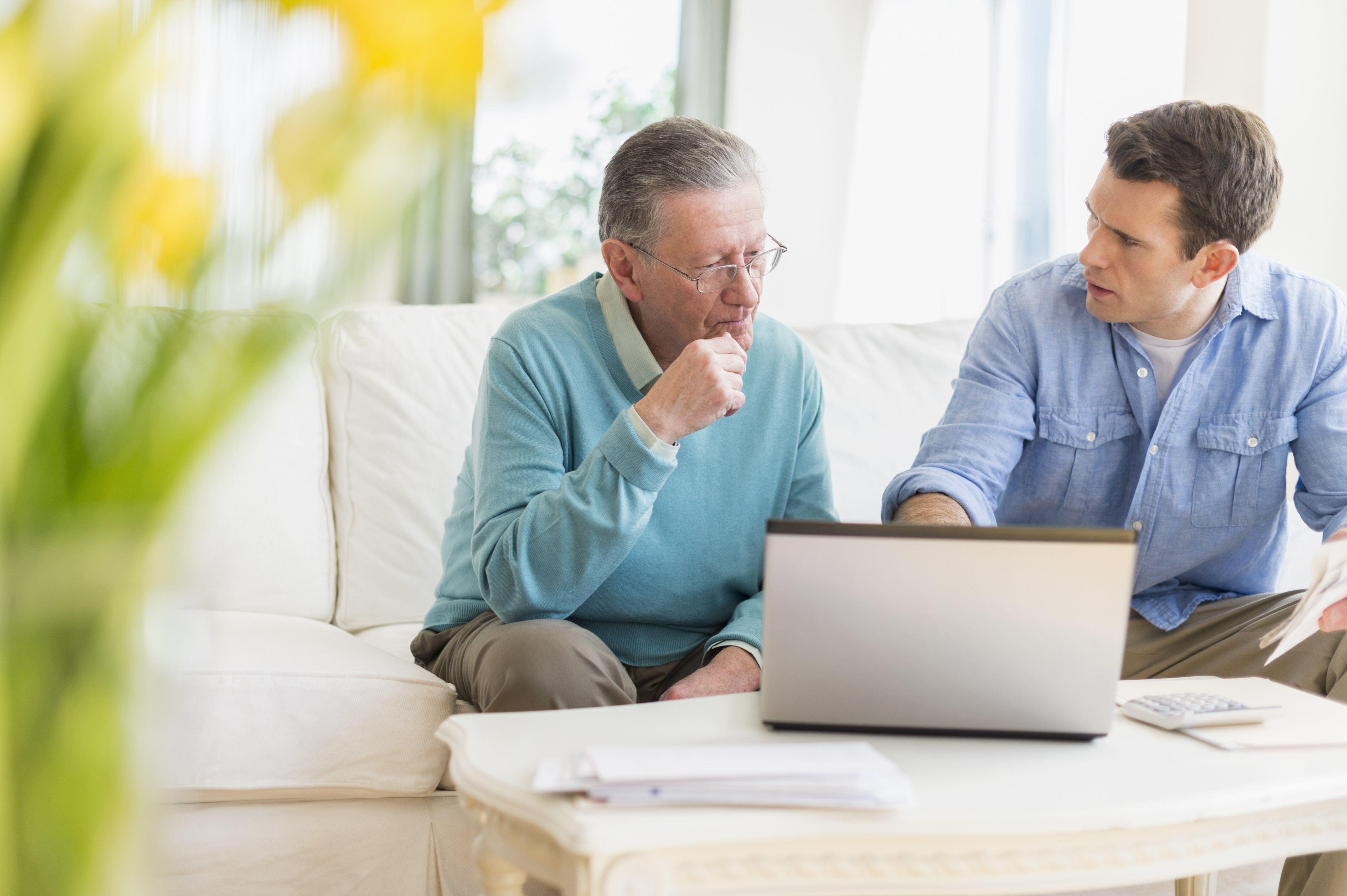 Un père et son fils discutant de quelque chose avec leur ordinateur portable ouvert | Source : Getty Images