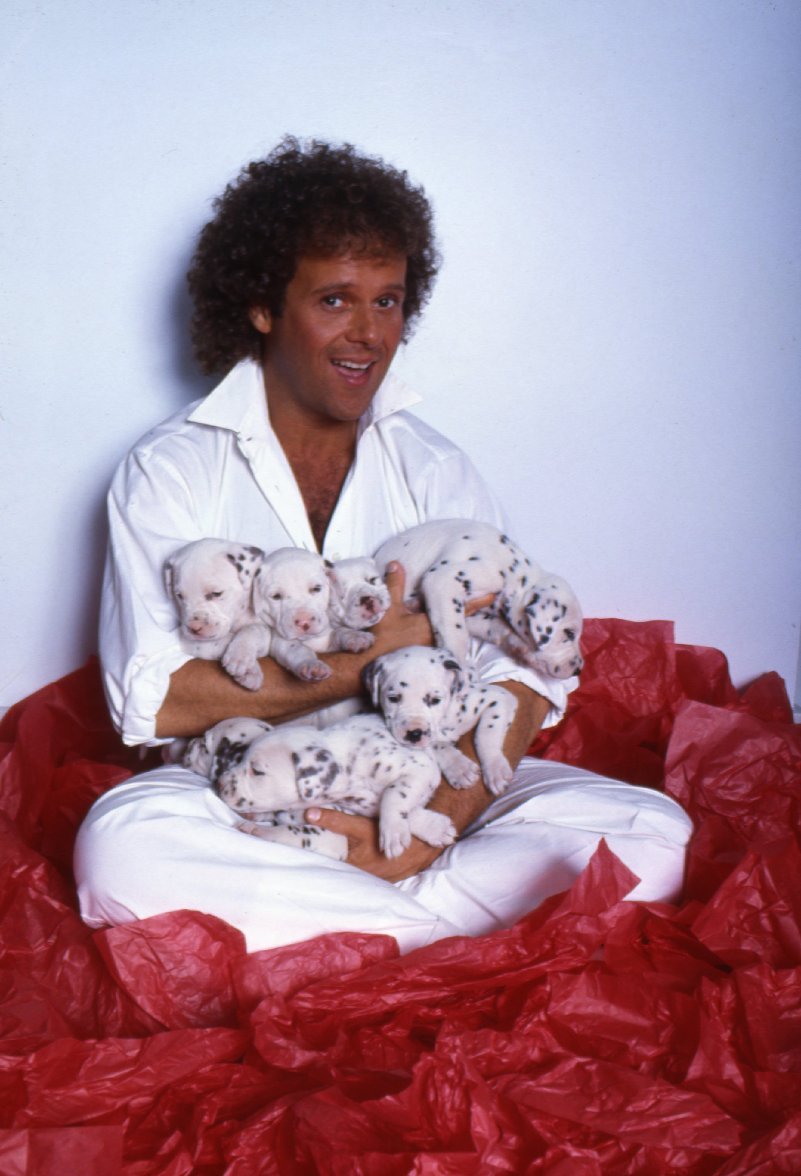 Richard Simmons pose pour un portrait avec des chiots dalmatiens le 2 juillet 1985 à Los Angeles, Californie | Source : Getty Images