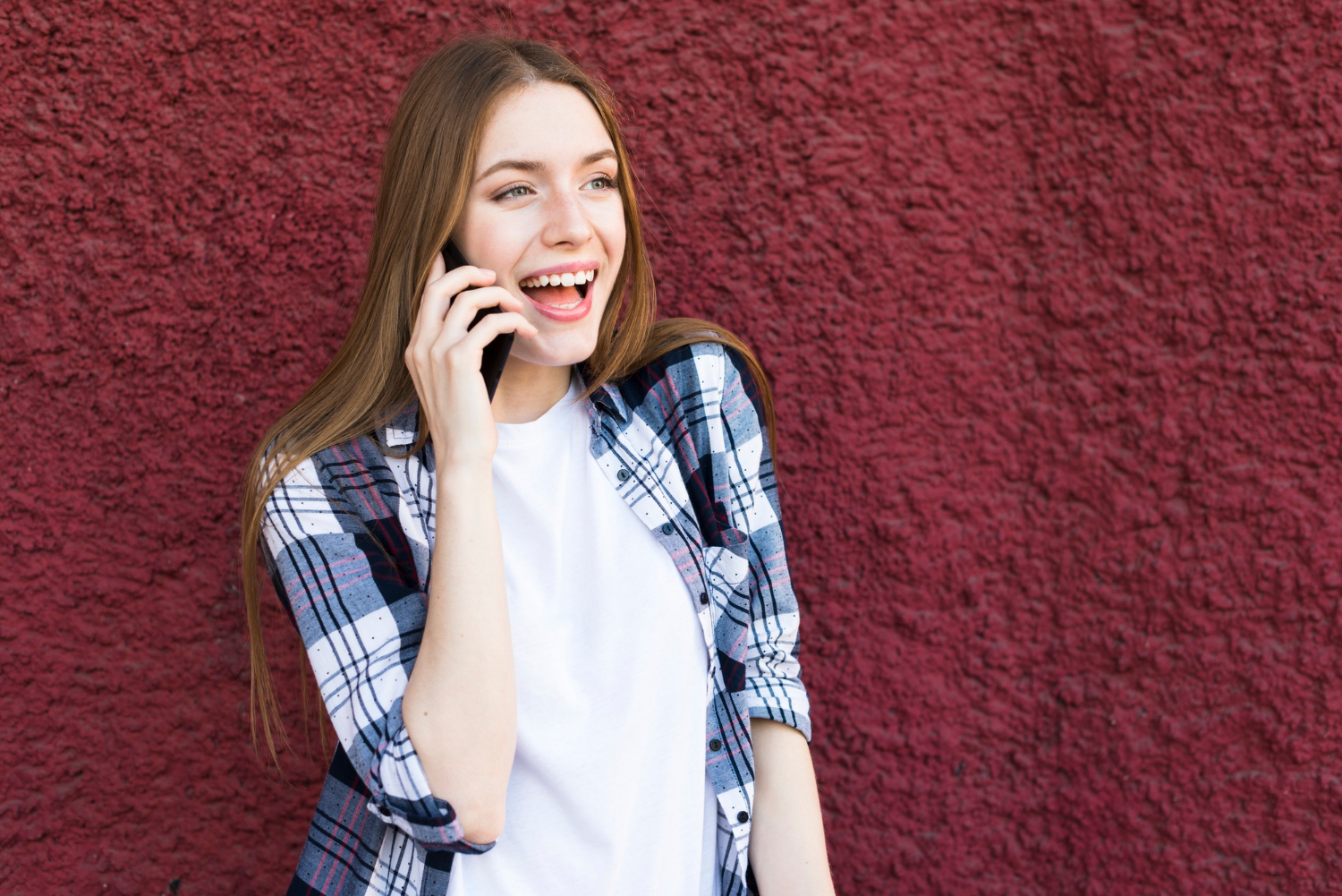 Une femme qui rit en parlant au téléphone | Source : Freepik