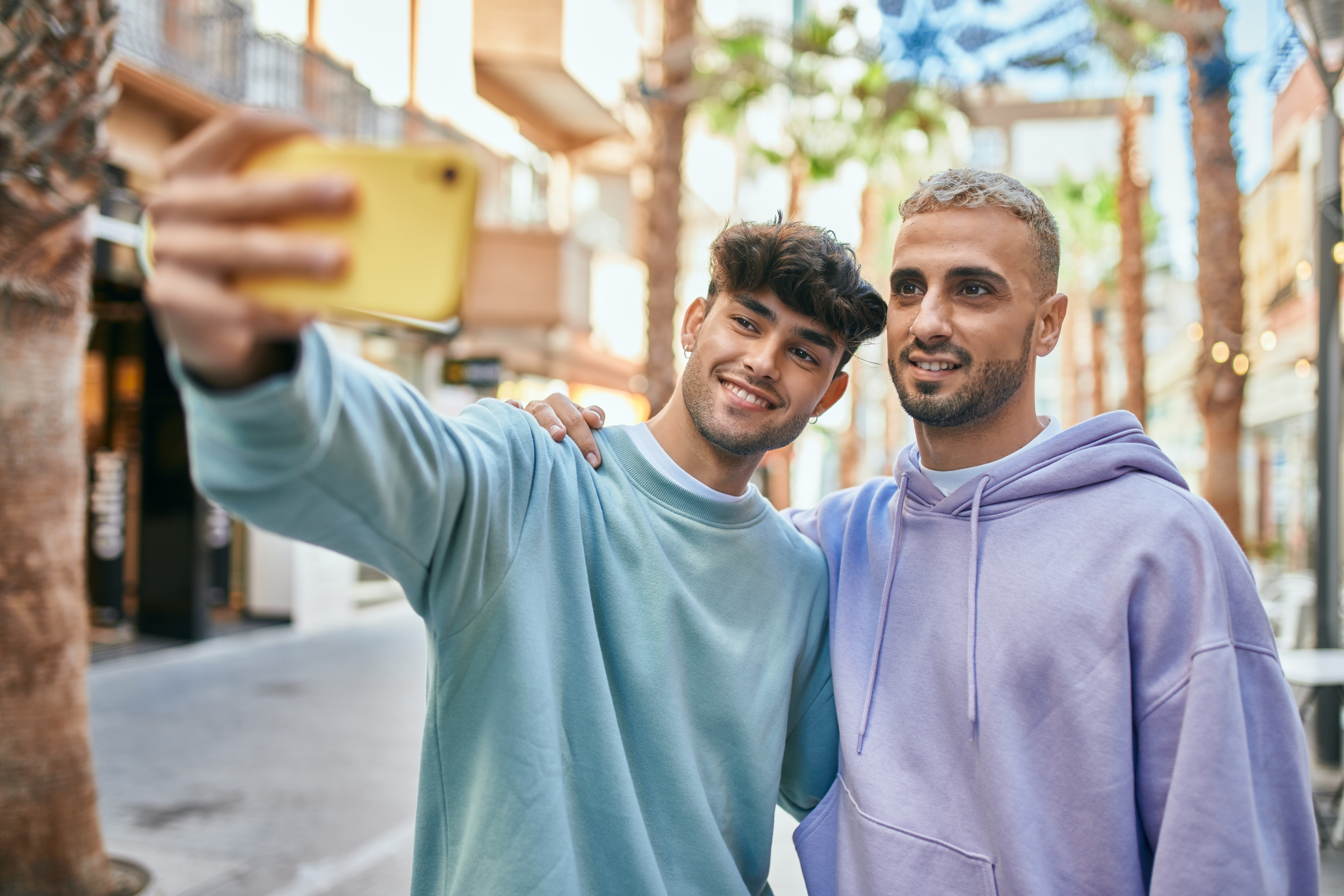 Deux jeunes hommes prenant une photo ensemble | Source : Shutterstock