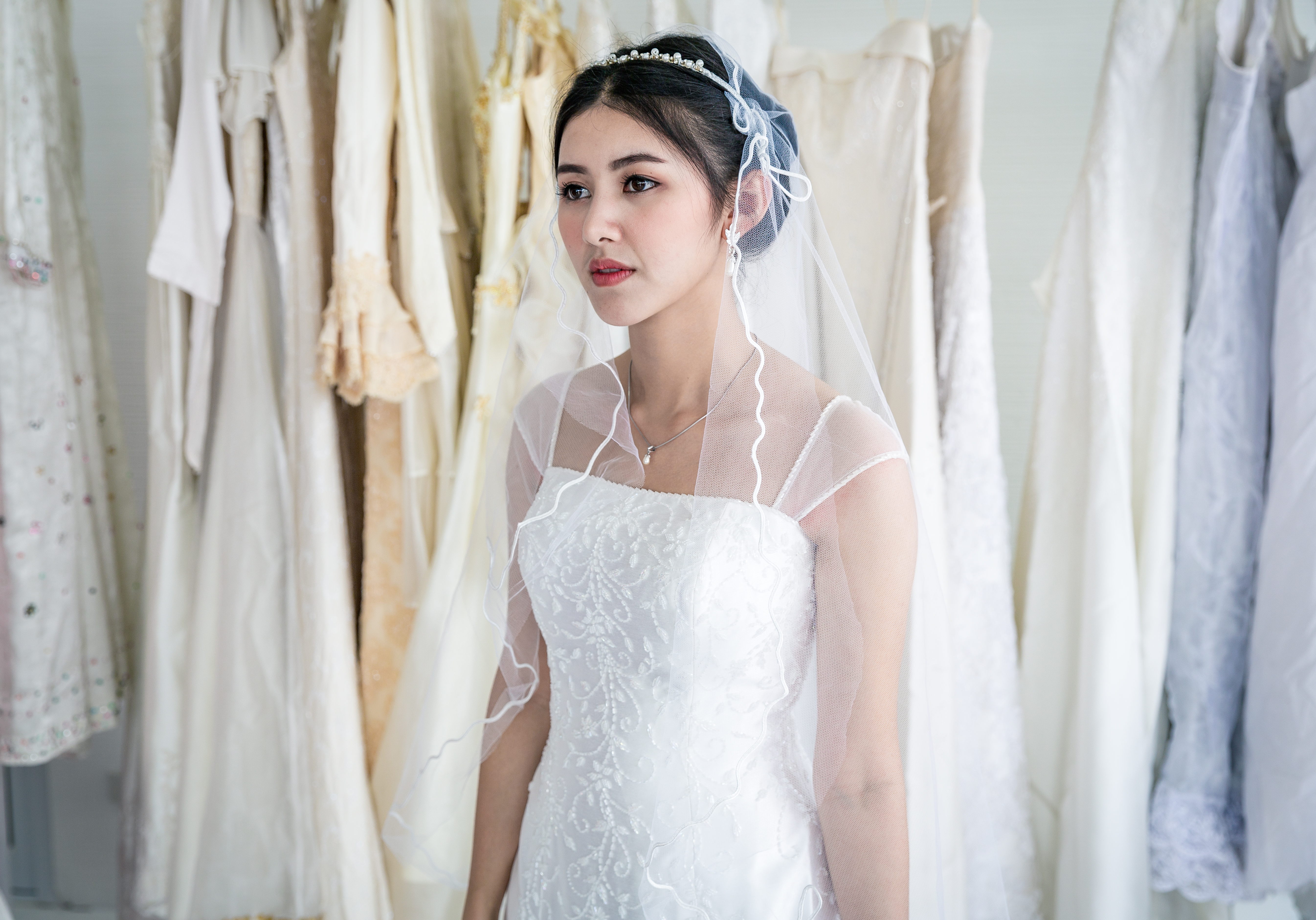 Belle mariée debout avec sa robe de mariée dans une chambre | Source : Getty Images