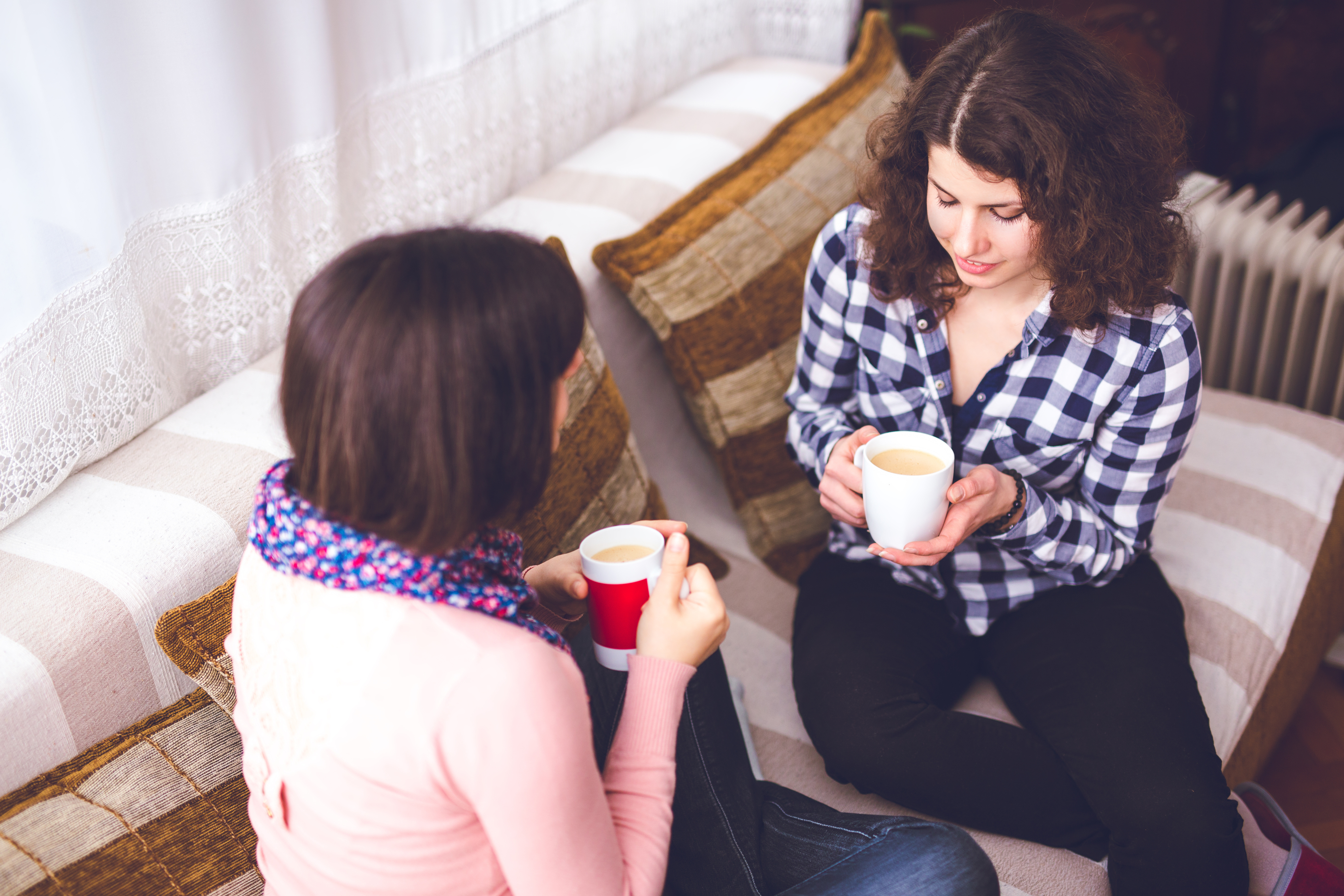 Deux femmes discutent en buvant un café | Source : Getty Images