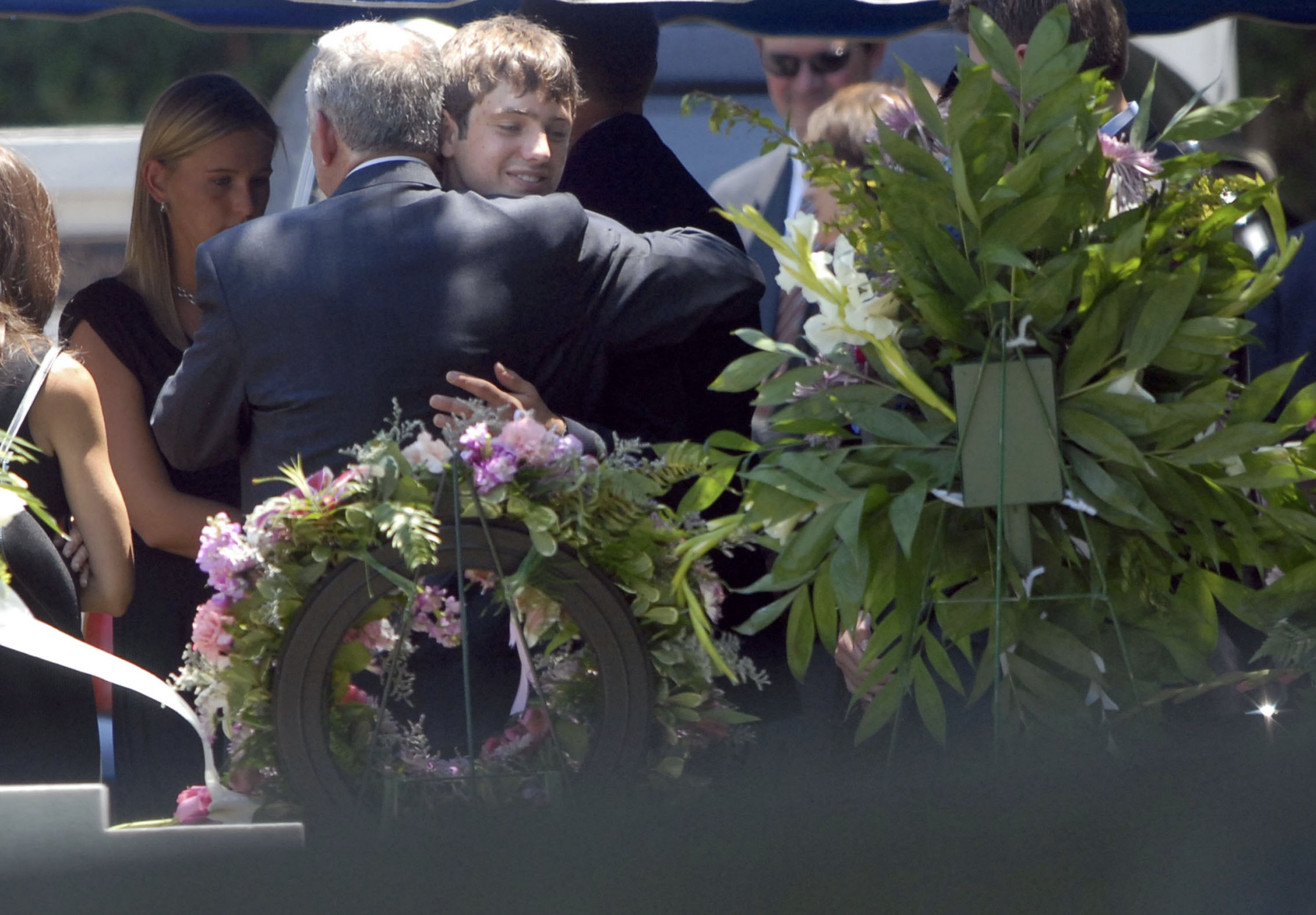 John Ramsey embrasse Burke Ramsey sur la tombe de JonBenet Ramsey, le 29 juin 2006, à Marietta, en Géorgie. | Source : Getty Images