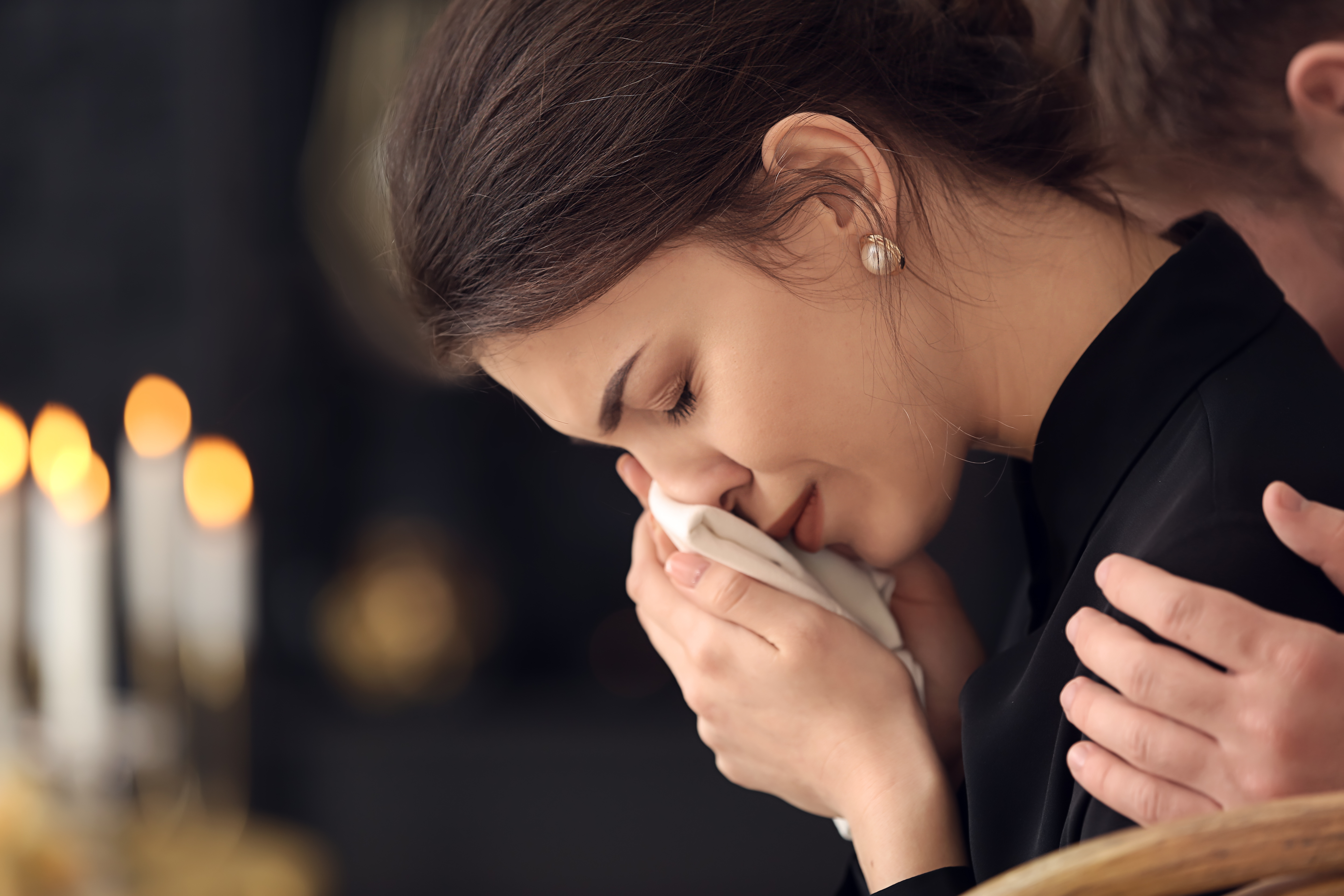 Une jeune femme qui pleure lors d'un enterrement | Source : Shutterstock
