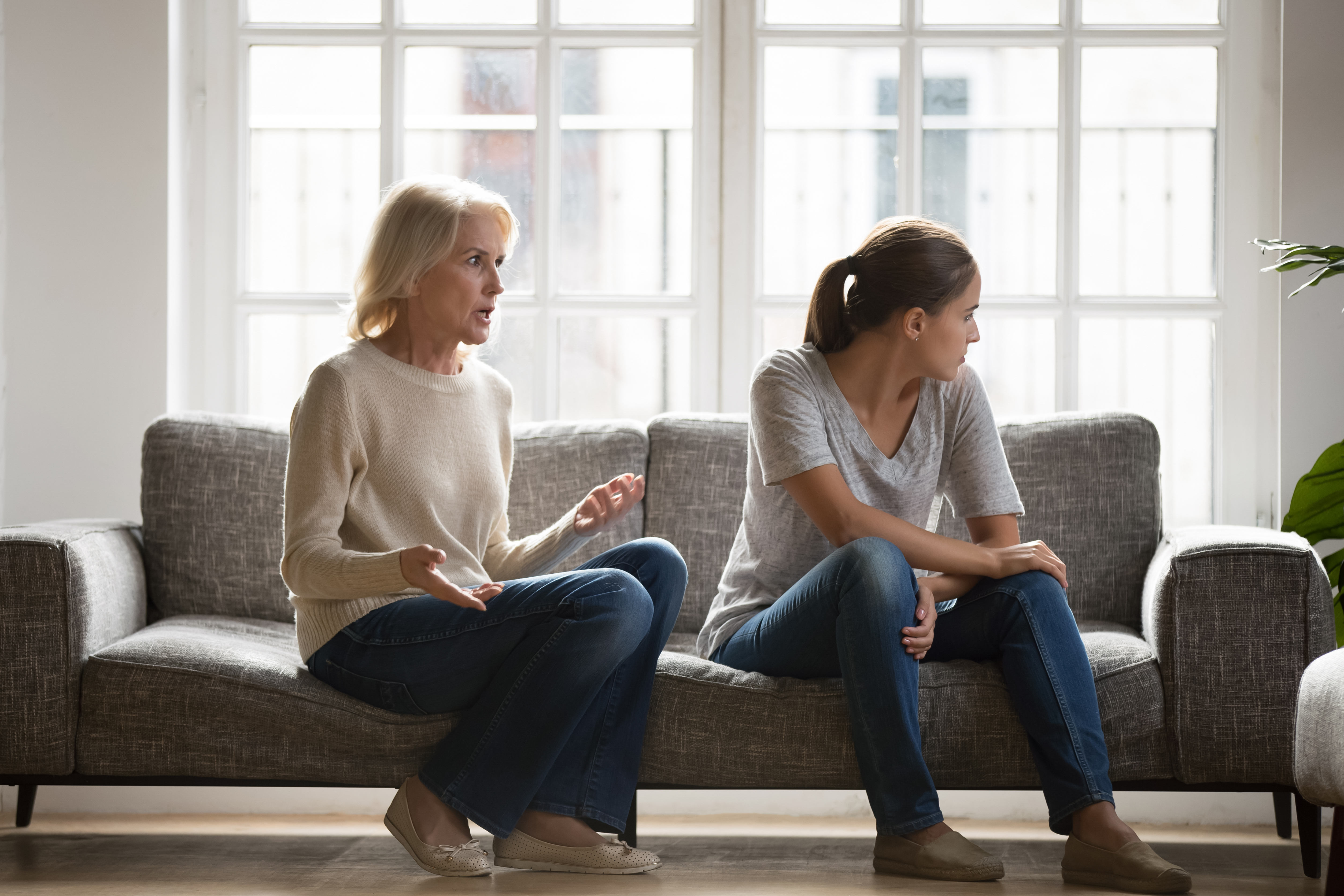 Une jeune femme stressée en désaccord avec sa maman âgée | Source : Shutterstock