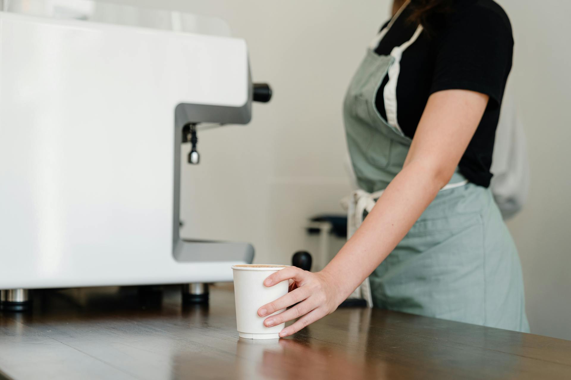 Gros plan d'une serveuse tenant une tasse de café | Source : Pexels