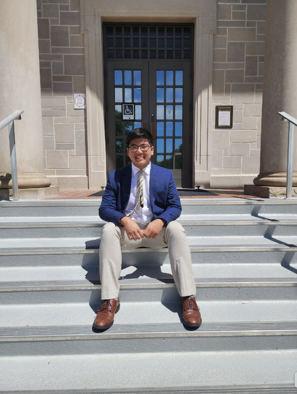 Austin Tran assis sur un escalier, dans une photo partagée le 6 mai 2025 | Source : Facebook/Austin Tran est vu à l'université de Notre Dam, en date du 6 avril 2025 | Source : Facebook/anntravels2