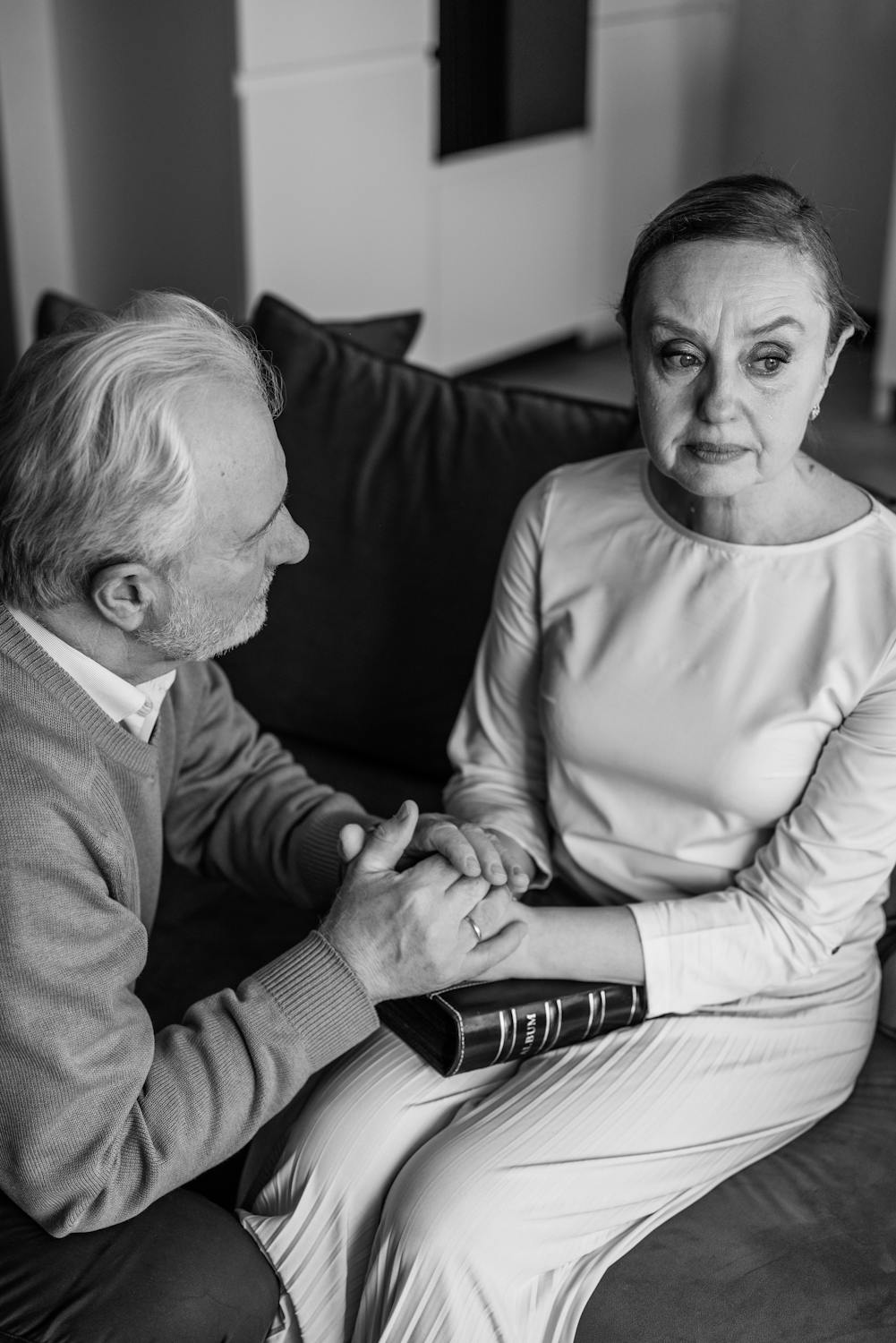 Une femme qui regarde ailleurs pendant que son mari la console ⏐ Source : Pexels