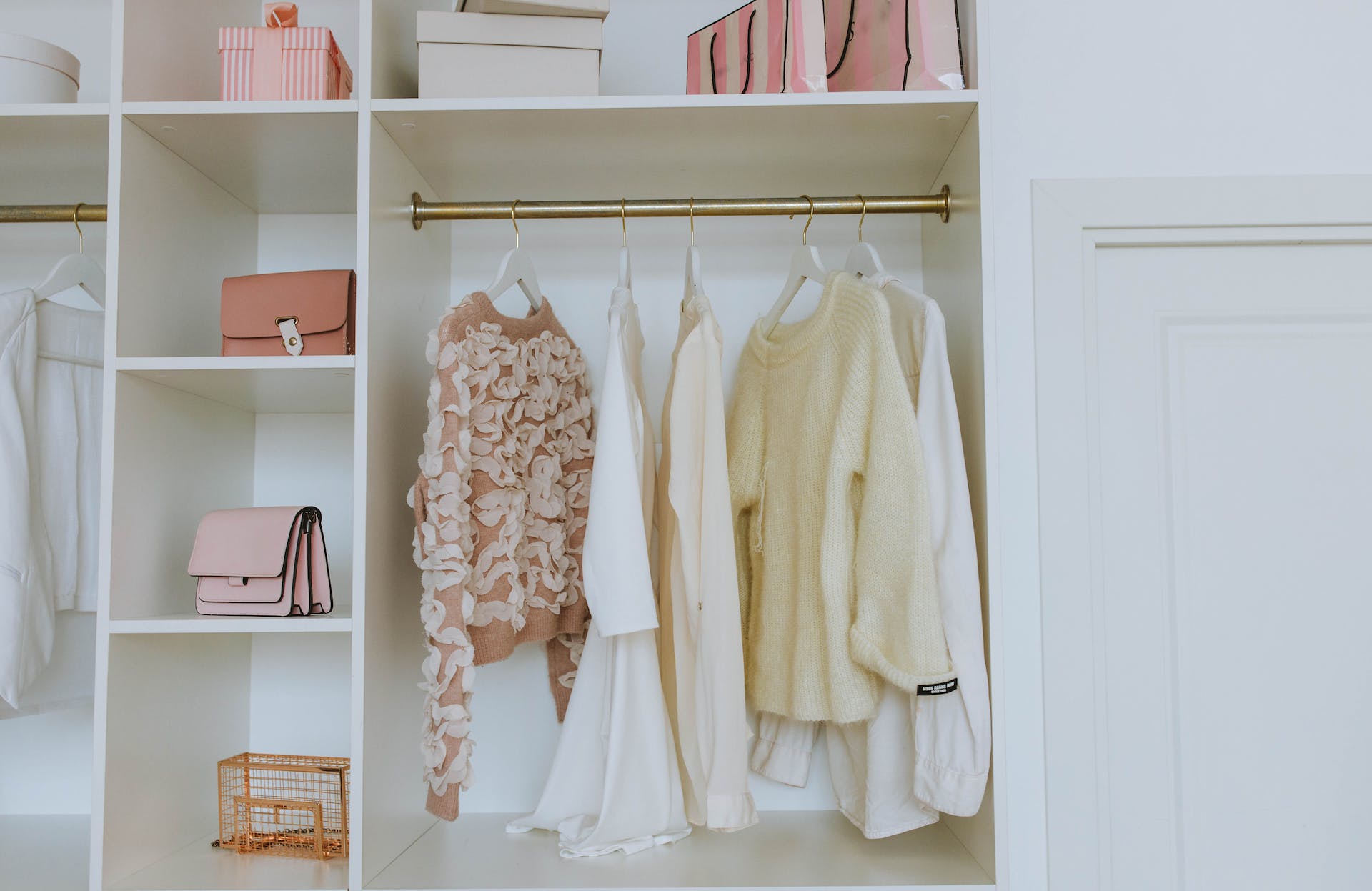 Placard en bois blanc avec des vêtements et d'autres objets | Source : Pexels