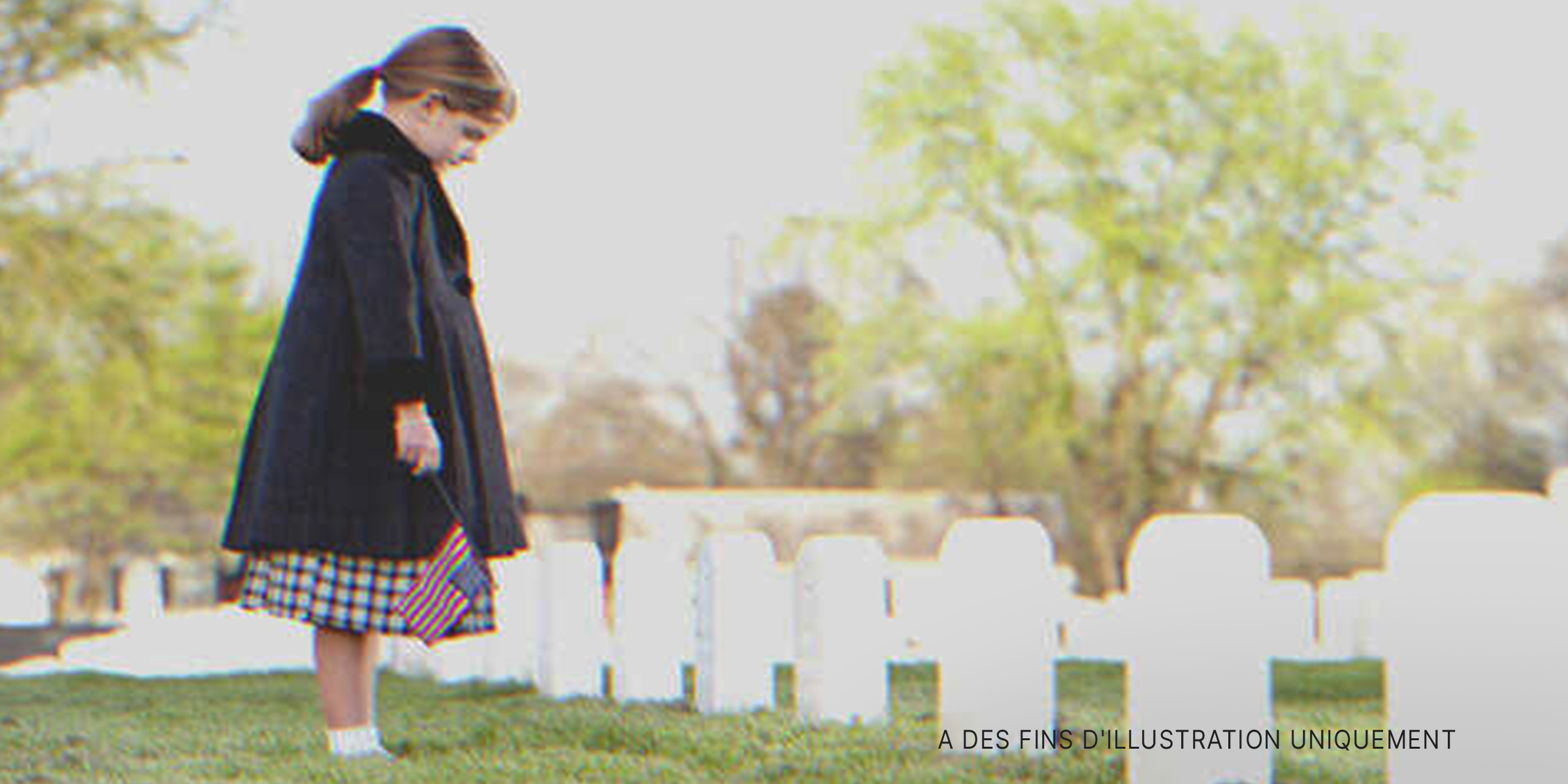 Une petite fille se recueillant sur une tombe | Source : Getty Images