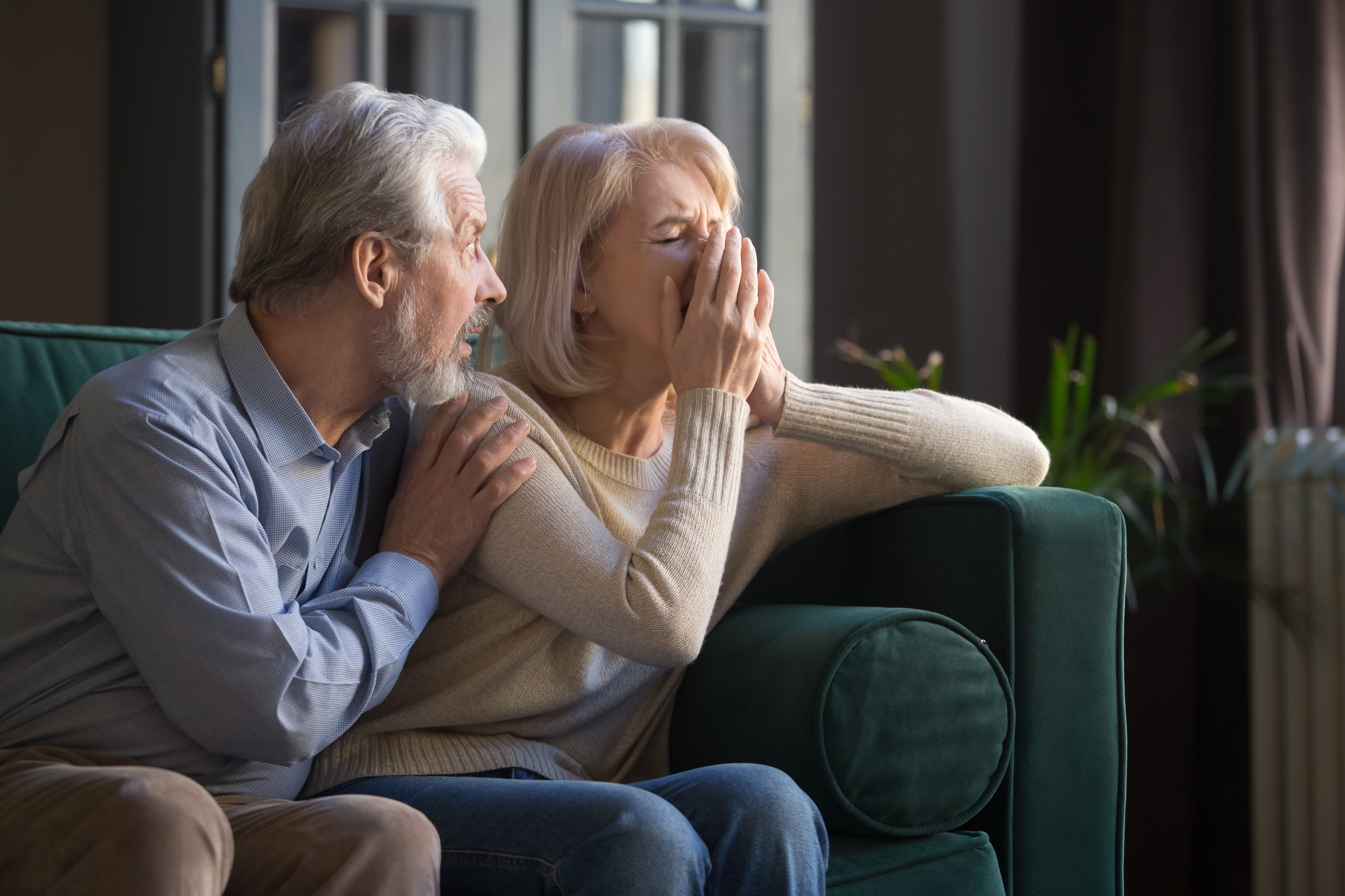 Une femme qui pleure tandis que son mari la réconforte. | Source : Shutterstock