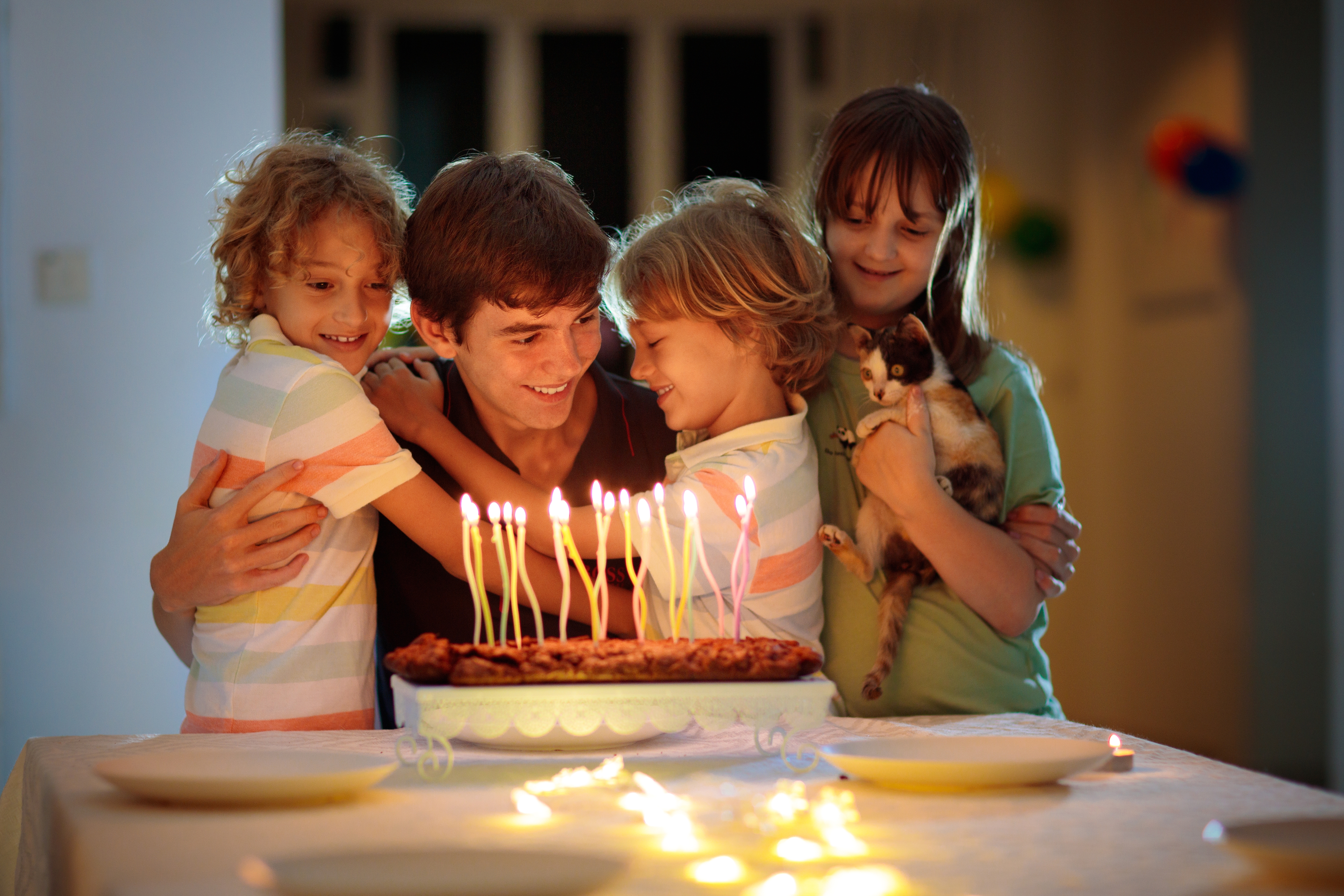 Un adolescent qui fête son anniversaire avec ses jeunes frères et sœurs | Source : Shutterstock