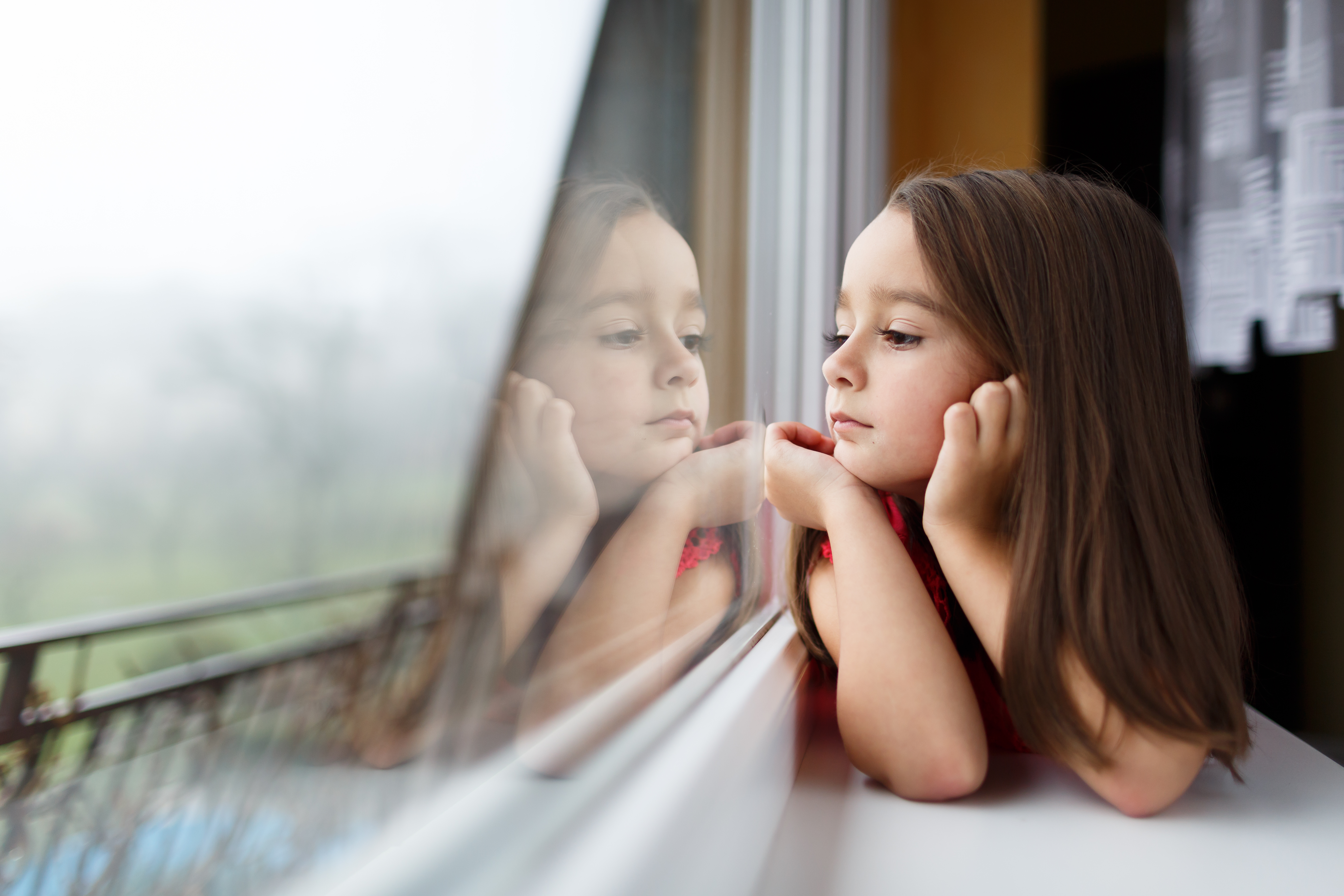 Petite fille regardant par la fenêtre | Source : Shutterstock