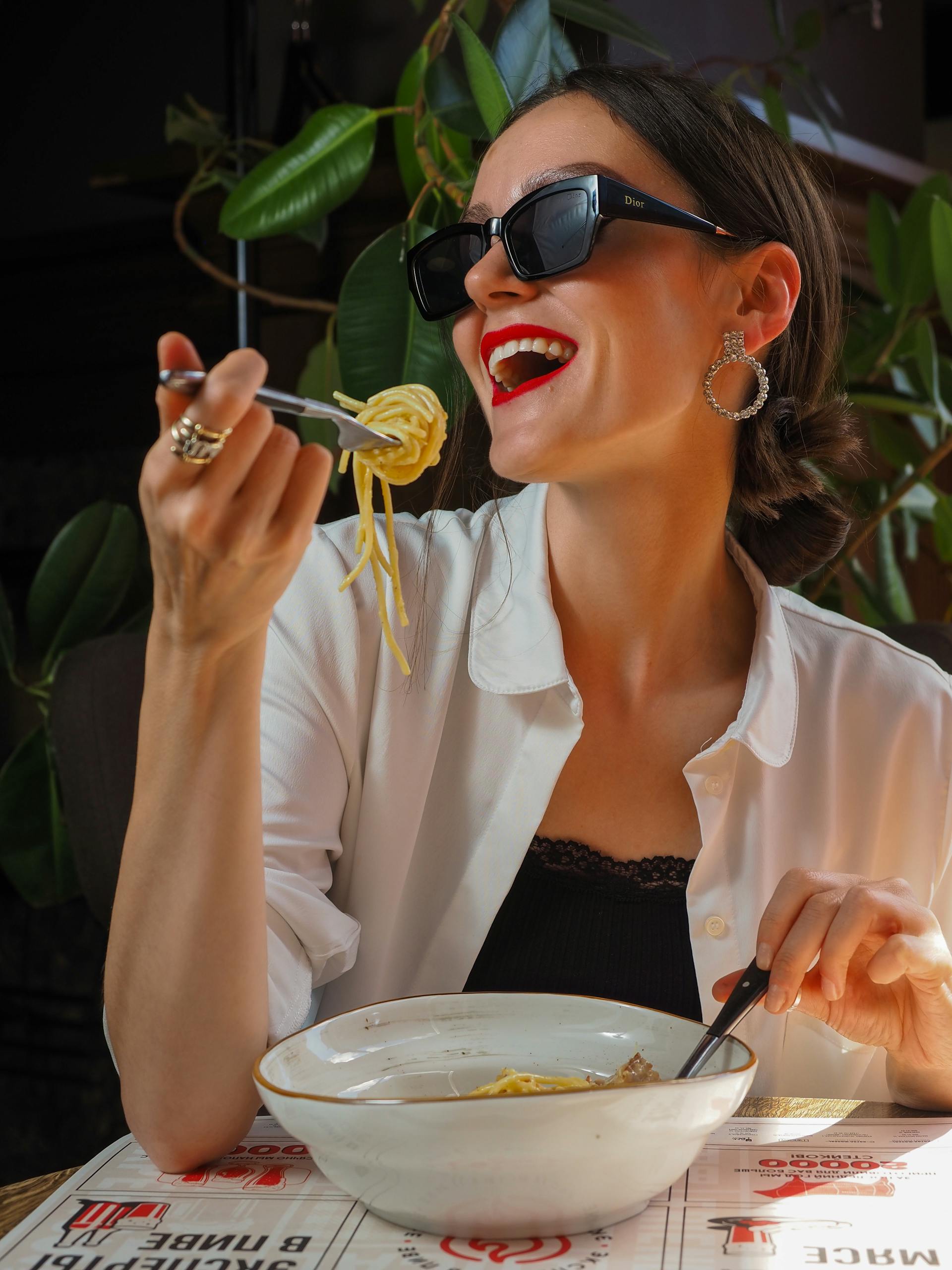 Femme souriante mangeant dans un restaurant | Source : Pexels