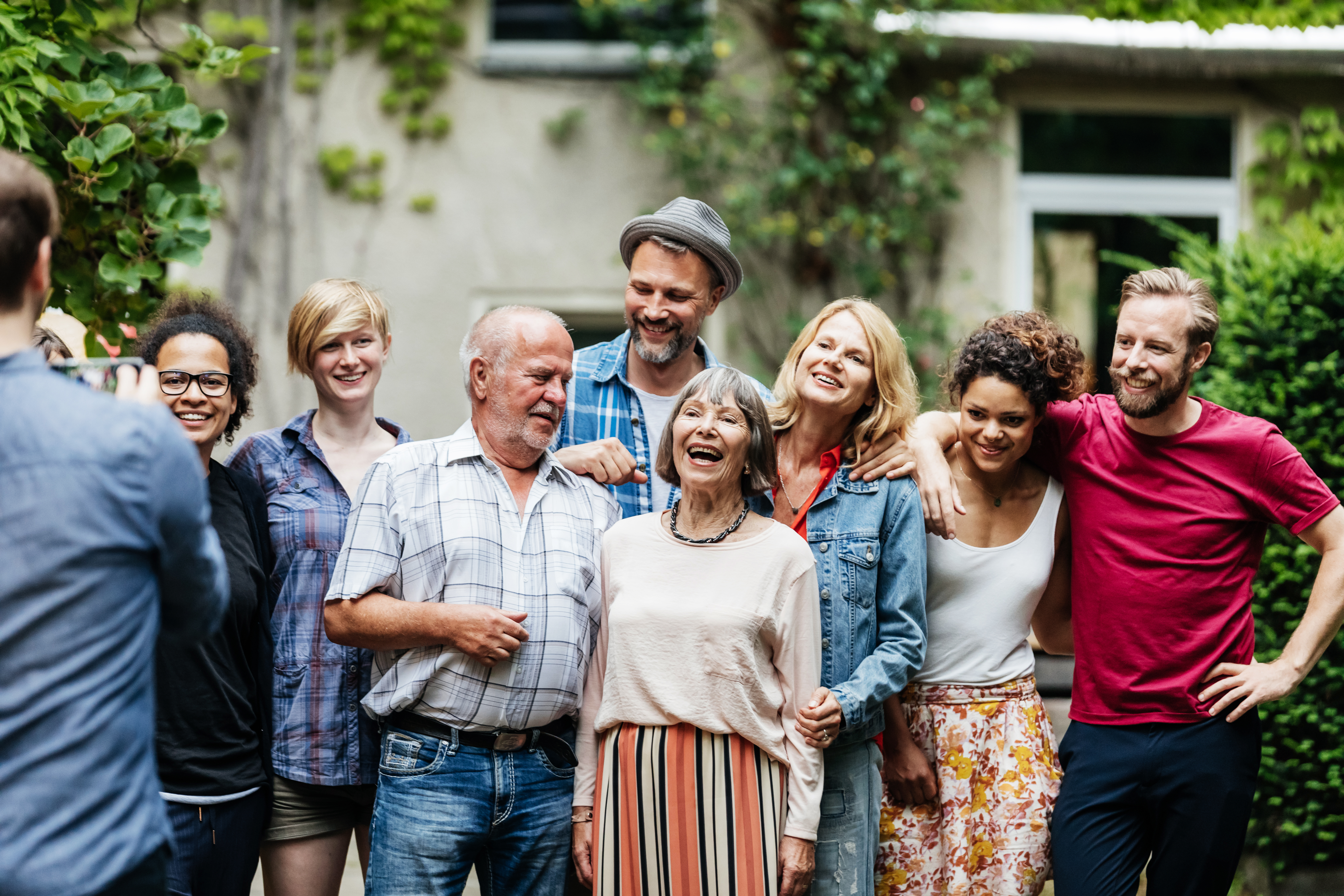 Homme prenant une photo de groupe de sa famille lors d'un barbecue | Source : Getty Images