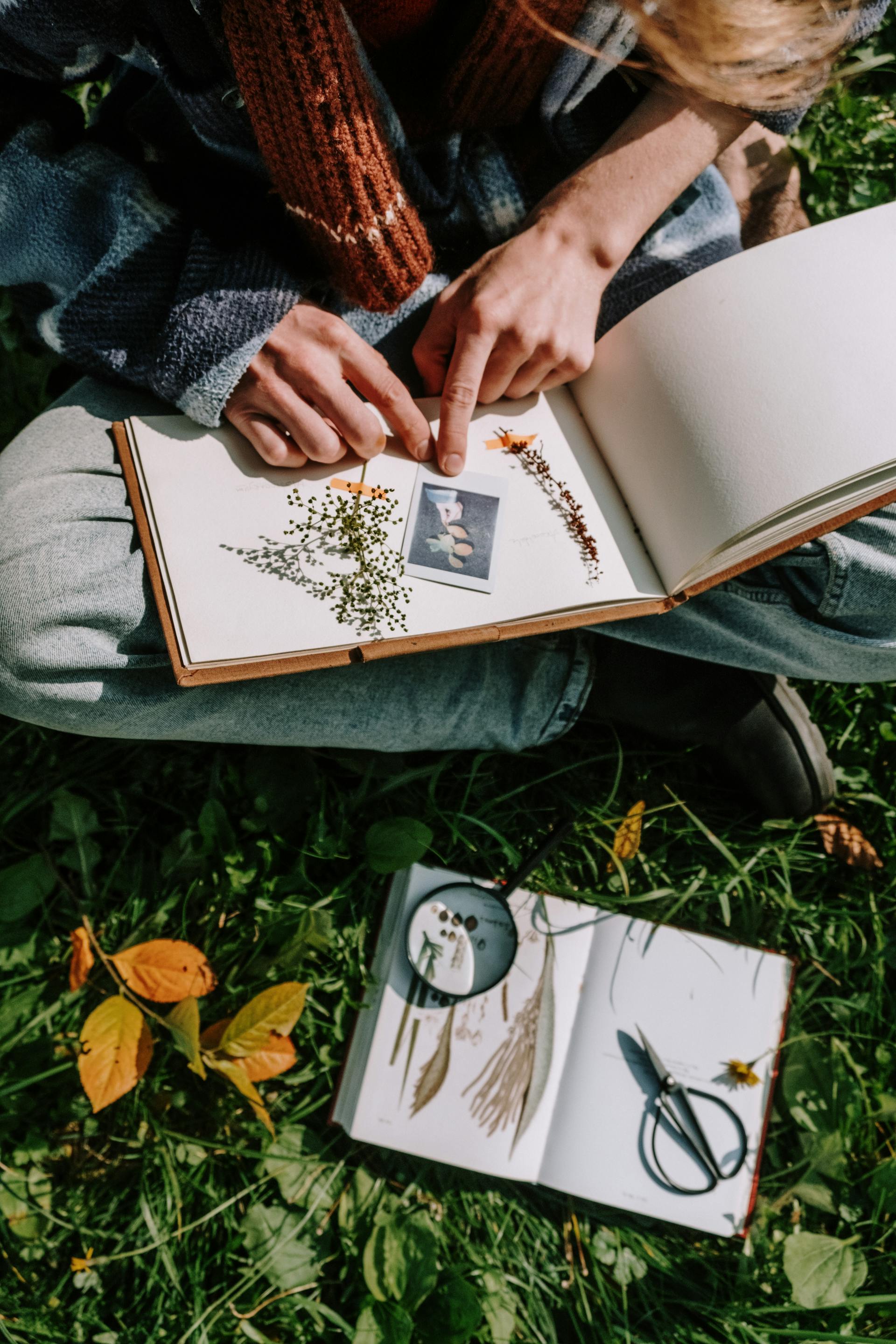 Une femme assise les jambes croisées et réalisant un album de coupures de presse | Source : Pexels