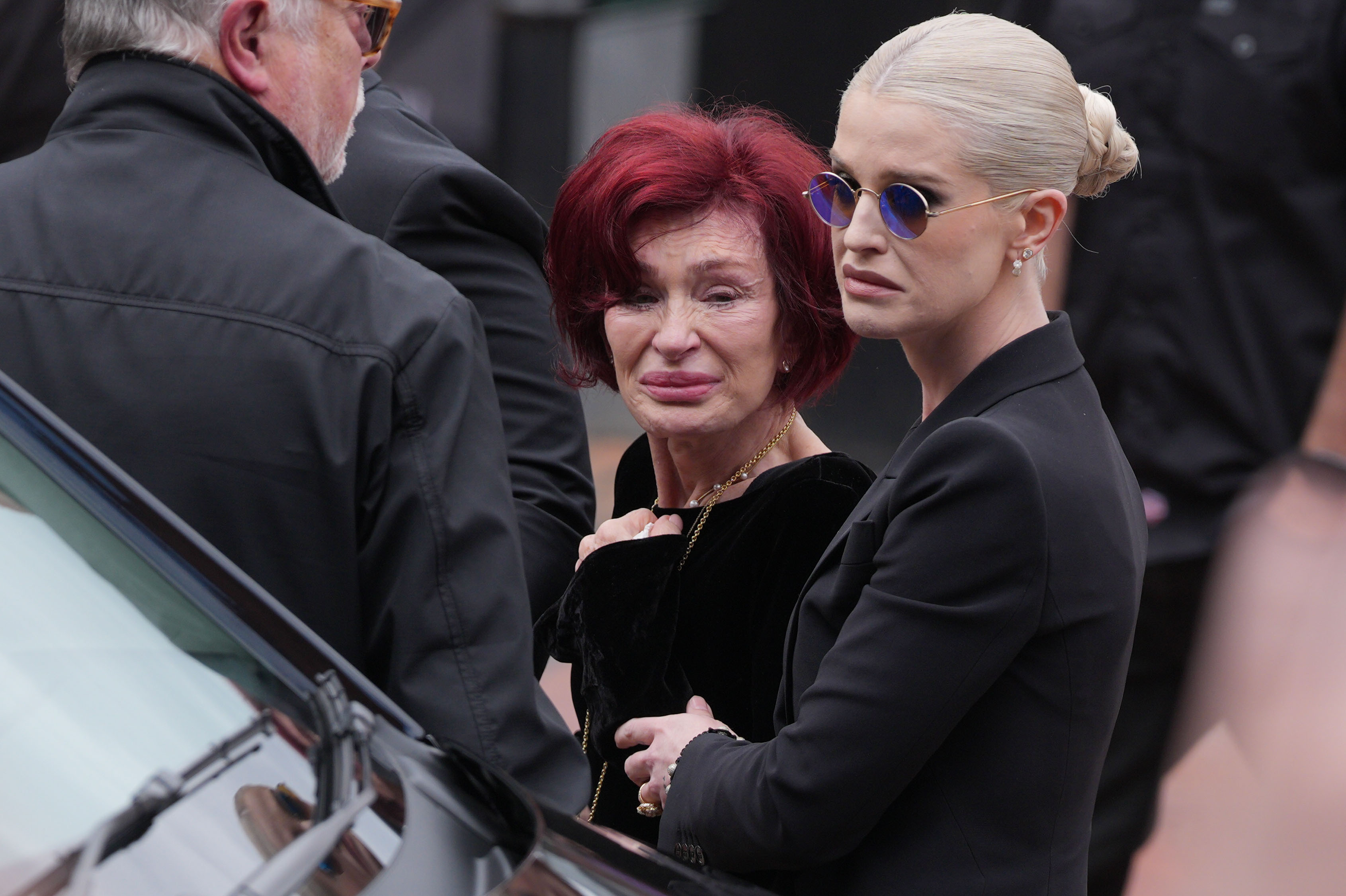Sharon et Kelly Osbourne s'arrêtent pour voir les hommages rendus à feu Ozzy Osbourne le 30 juillet 2025 à Birmingham, en Angleterre. | Source : Getty Images