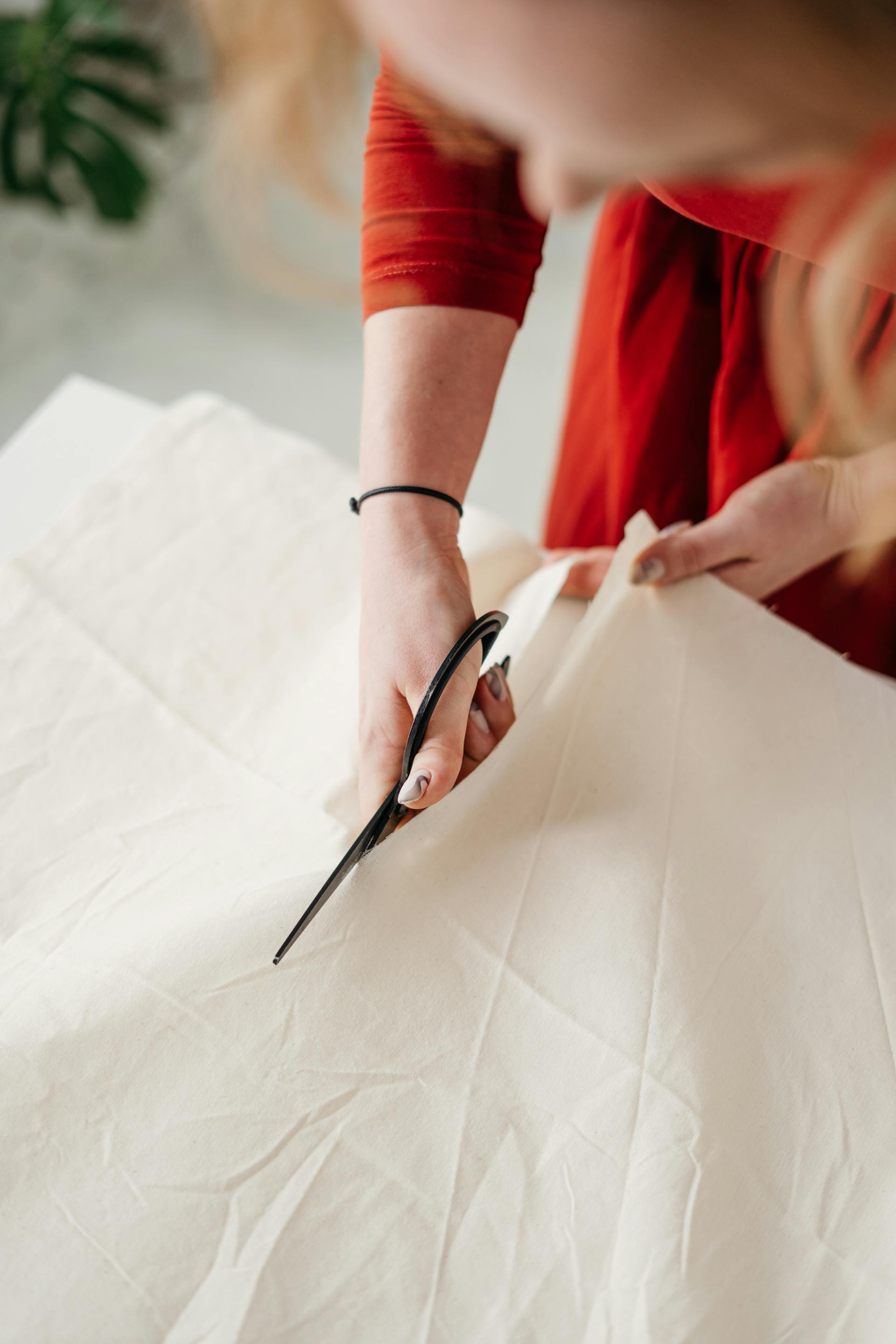 Une femme en train de couper une robe | Source : Pexels