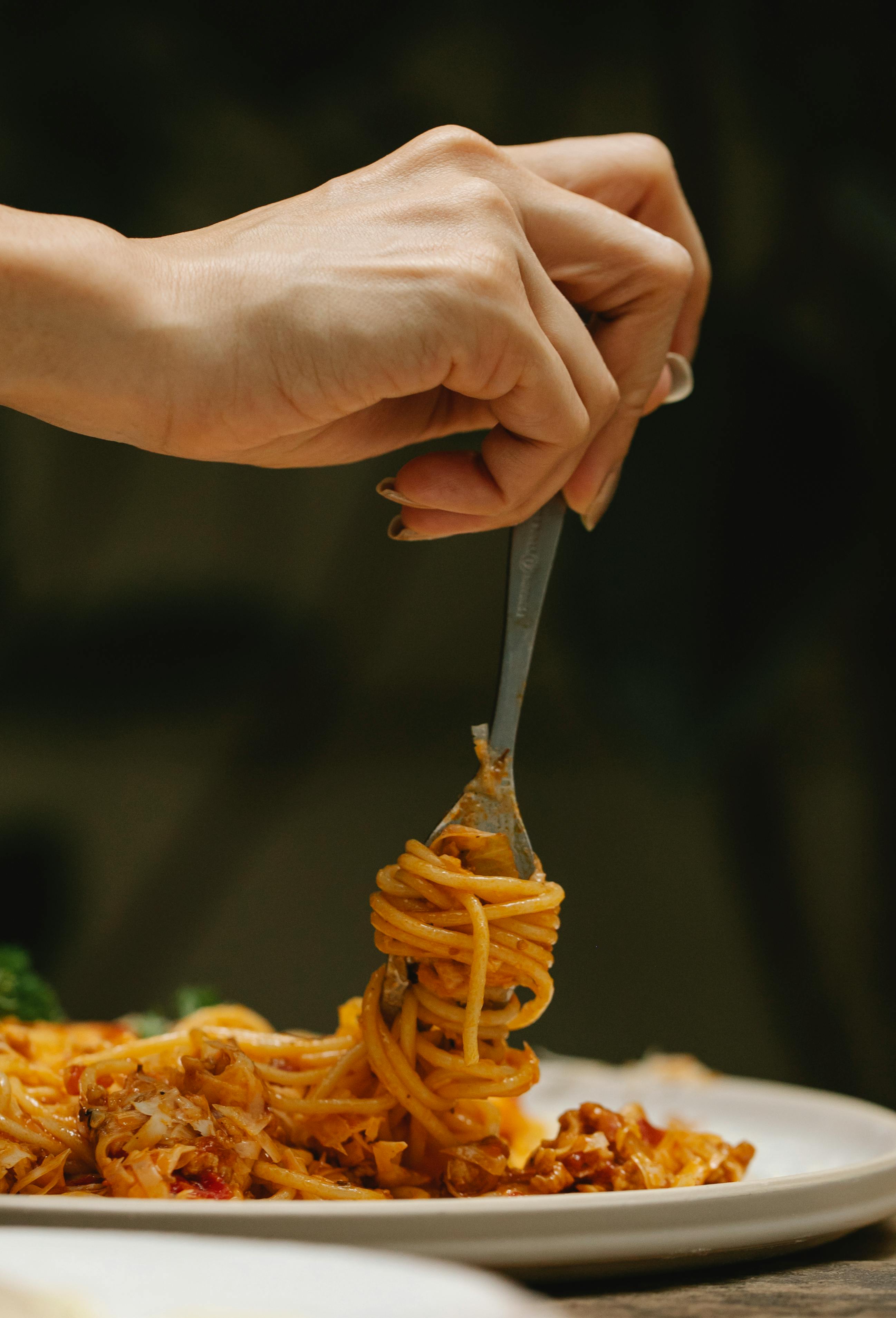 Femme roulant des spaghettis sur une fourchette | Source : Pexels
