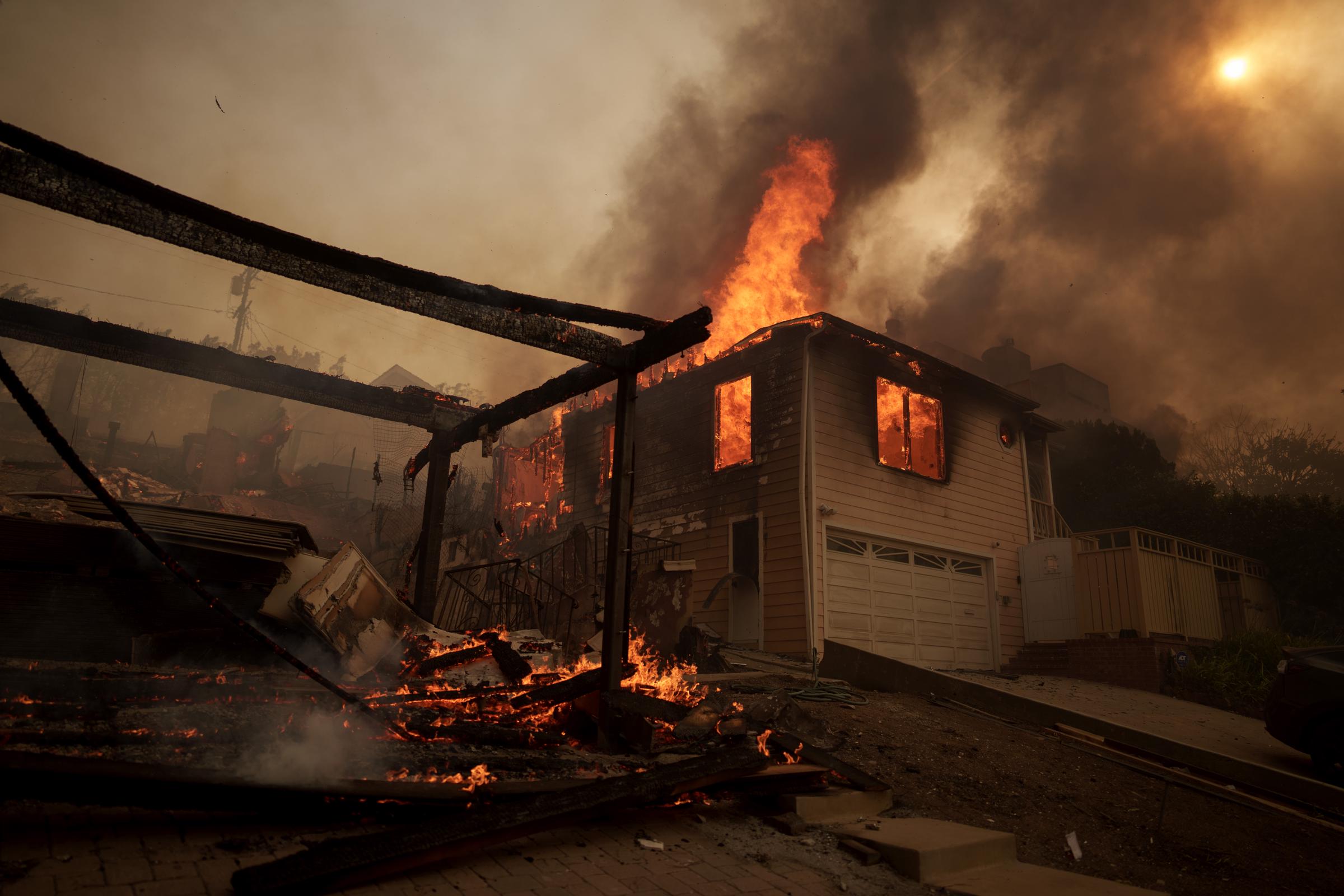 Les flammes de l'incendie de Palisades brûlent une maison le 8 janvier 2025, dans le quartier de Pacific Palisades à Los Angeles, en Californie | Source : Getty Images