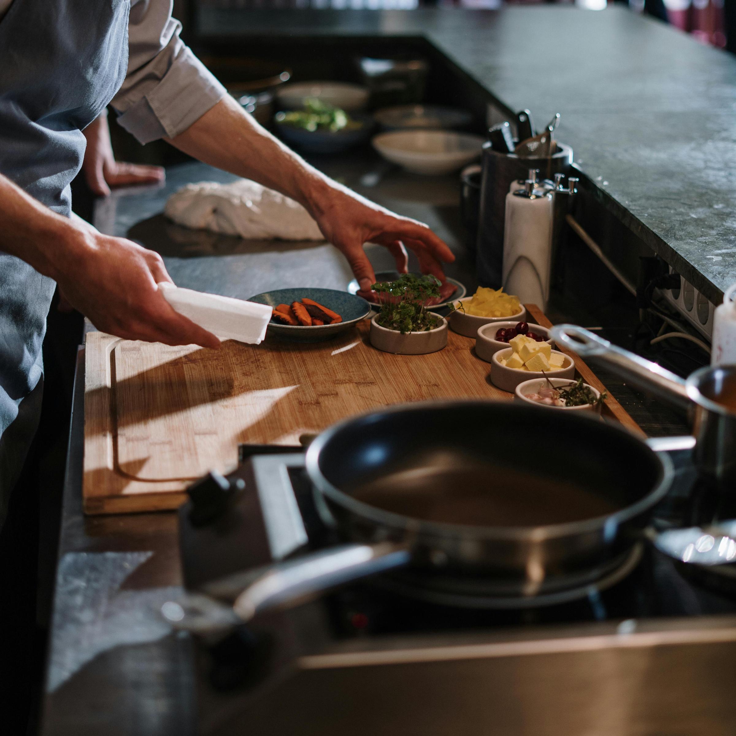 Un homme se prépare à cuisiner avec une variété de produits alimentaires et d'ustensiles | Source : Pexels