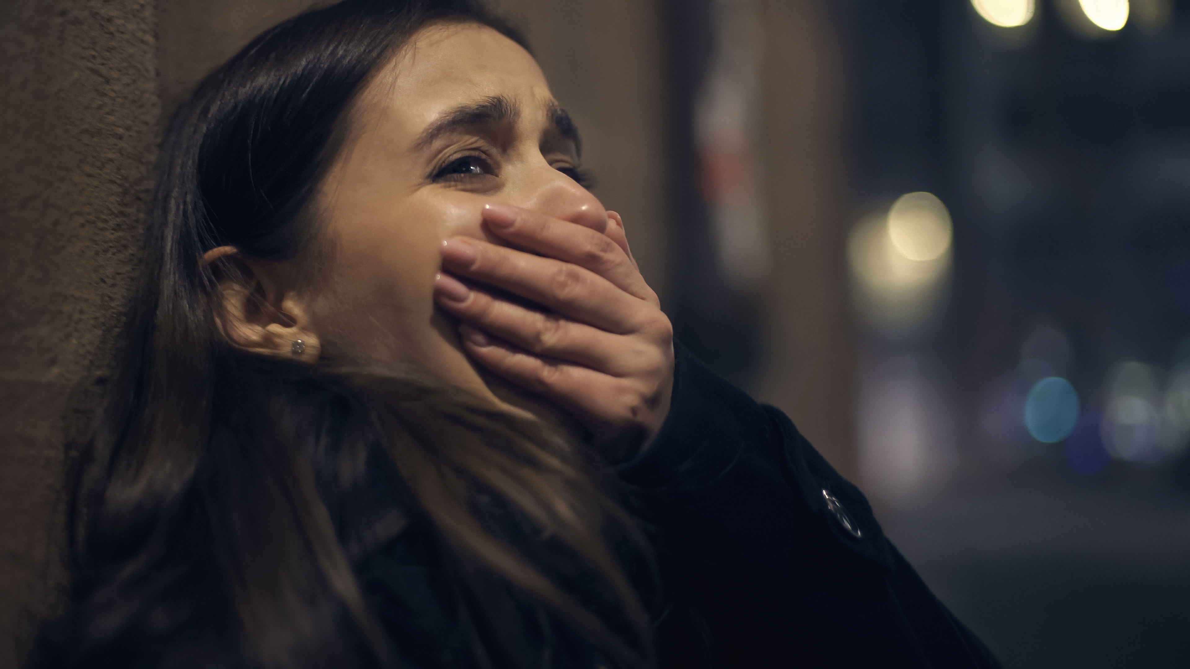 Une femme effrayée qui pleure avec sa main serrée sur sa bouche | Source : Shutterstock