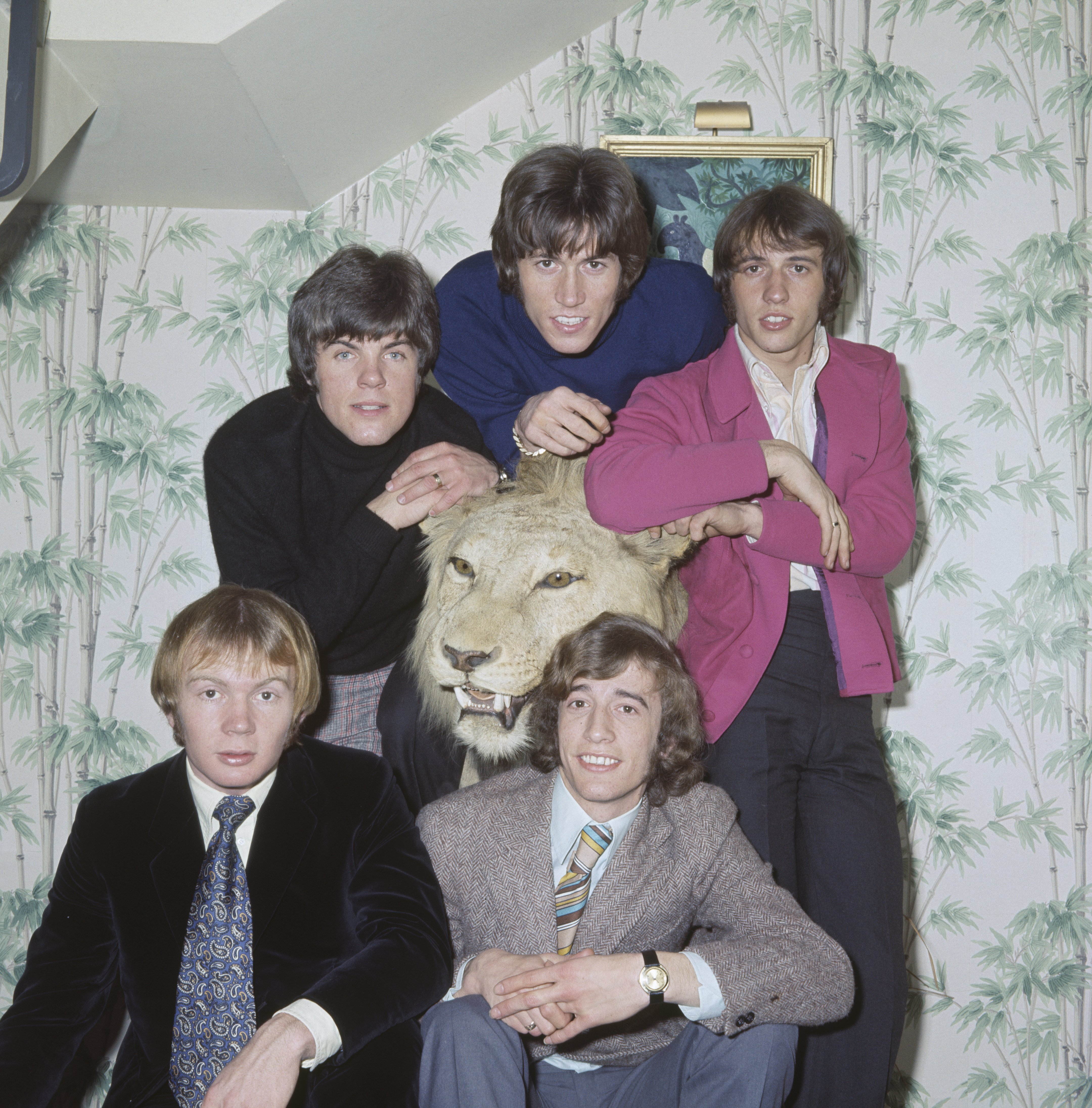 Les Bee Gees posent pour une photo en 1967 avec des amis et leur frère Andy Gibb | Source : Getty Images