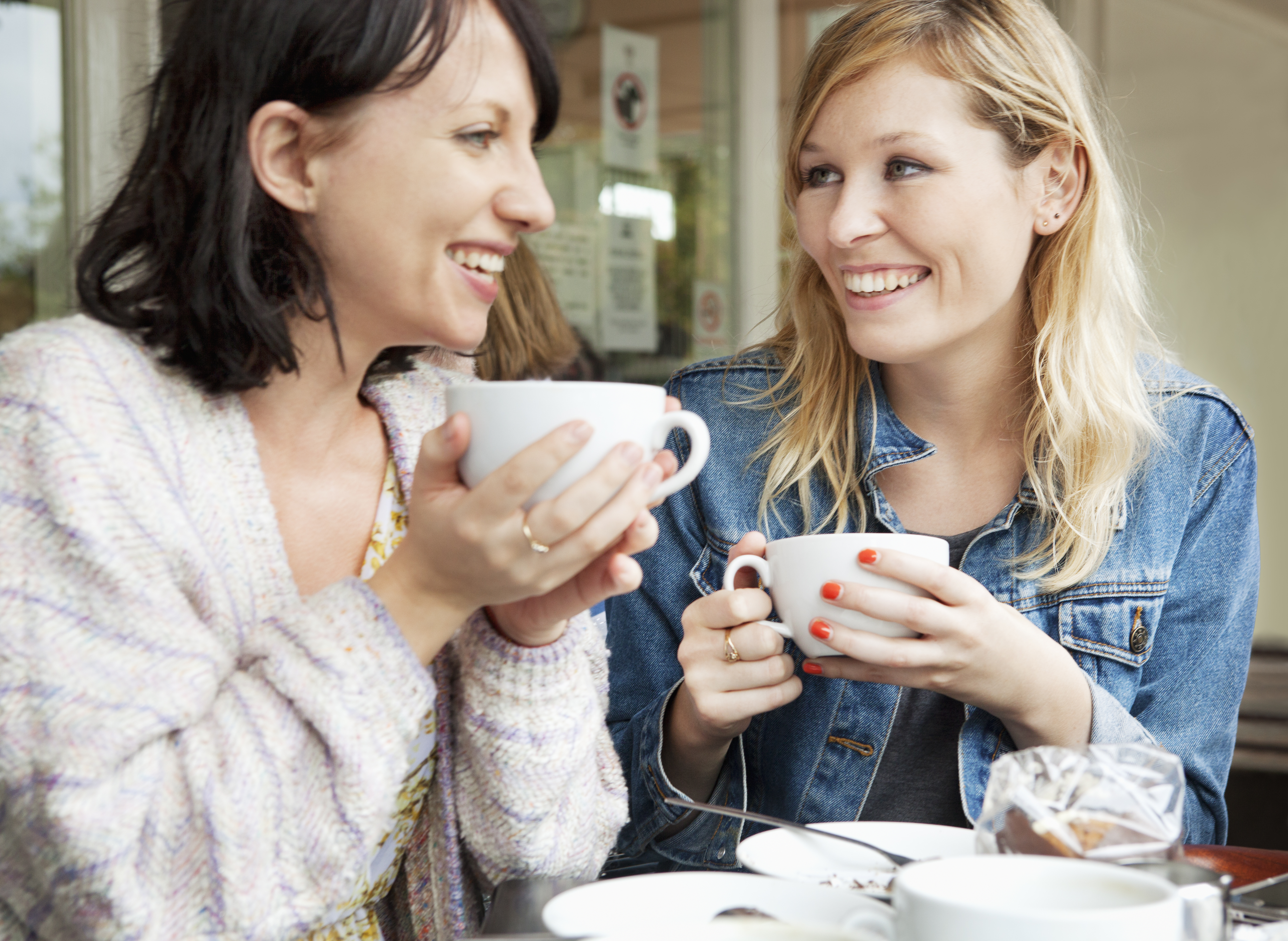 Deux femmes se rapprochent autour d'un café | Source : Getty Images