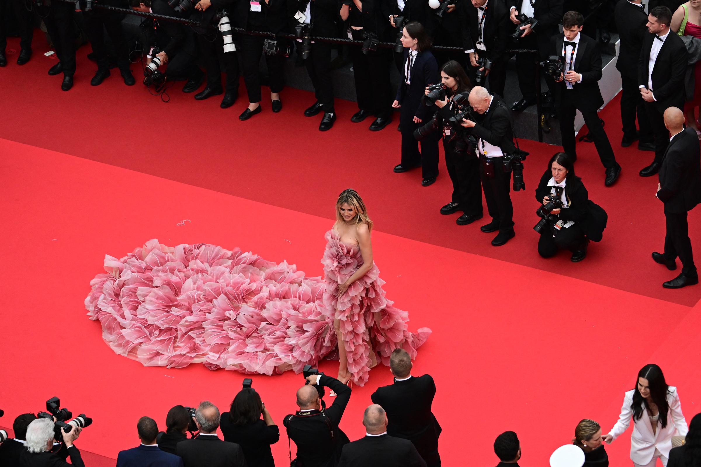 Le moment semble cinématographique - Heidi Klum se tient au centre du tapis rouge, prenant la pose tandis que les photographes l'entourent, chacun désireux de la capturer sous tous les angles, dans toute sa gloire à couper le souffle.
