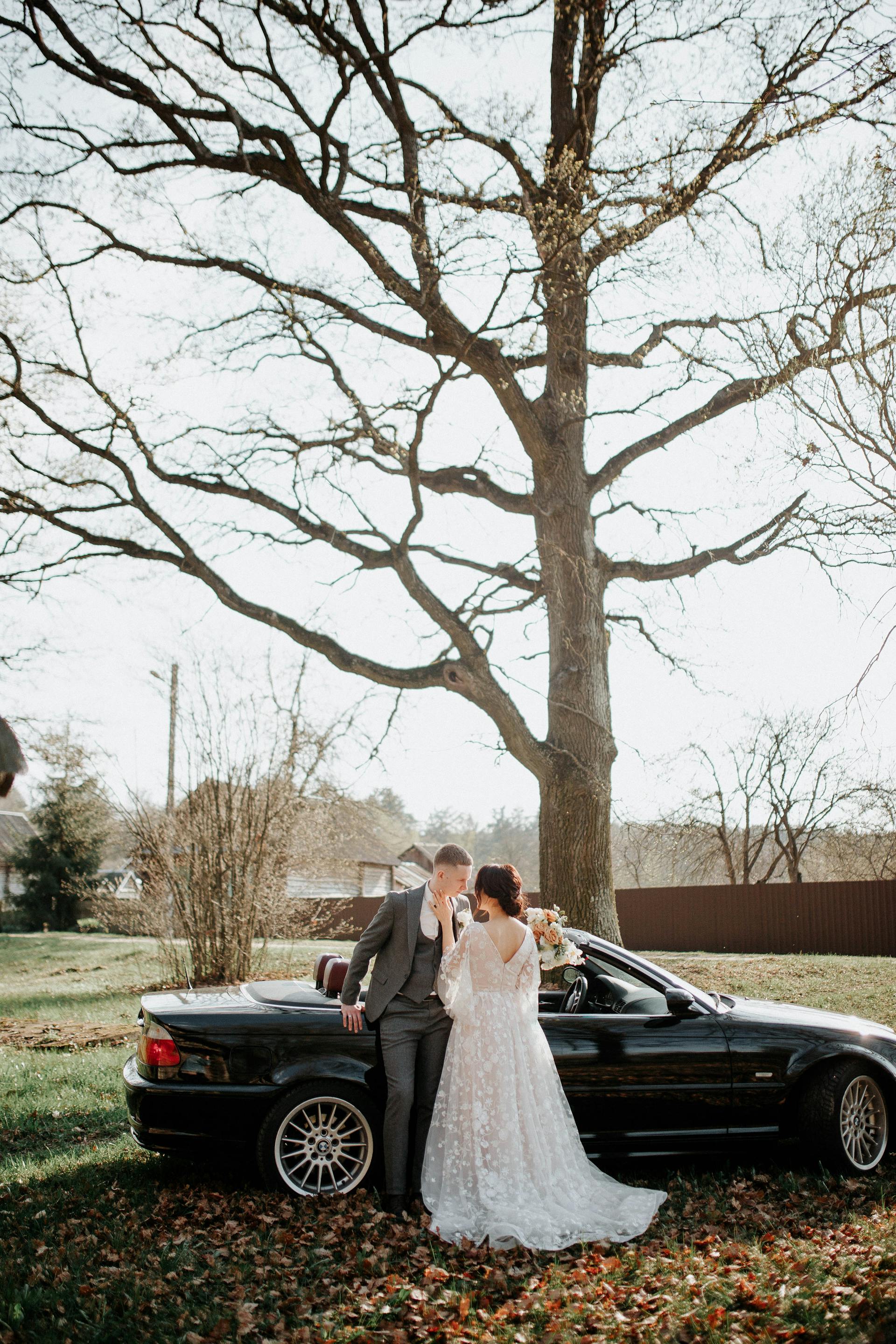 Une mariée et un marié debout à côté d'une voiture | Source : Pexels