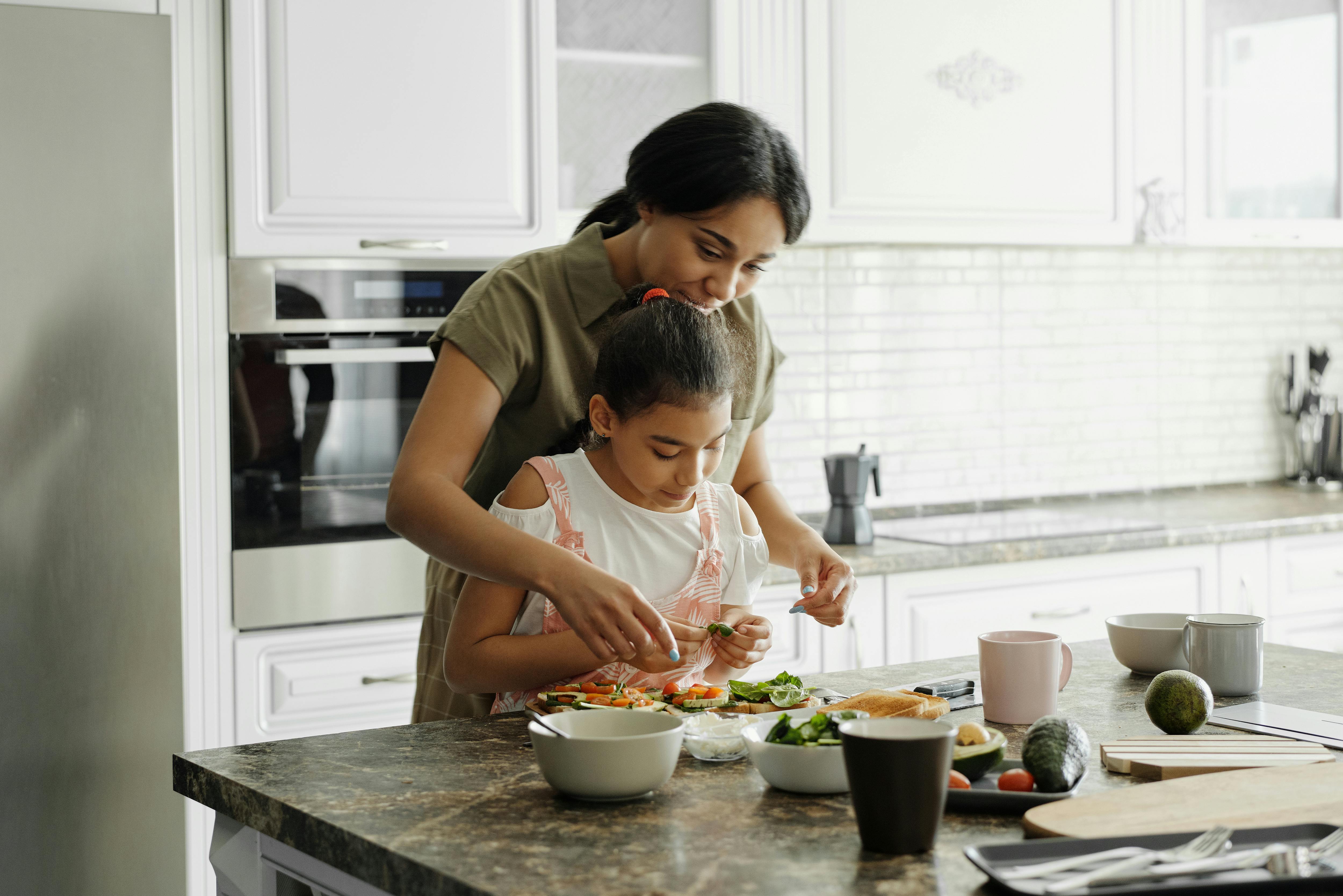 Une petite fille à qui sa mère apprend à cuisiner | Source : Pexels
