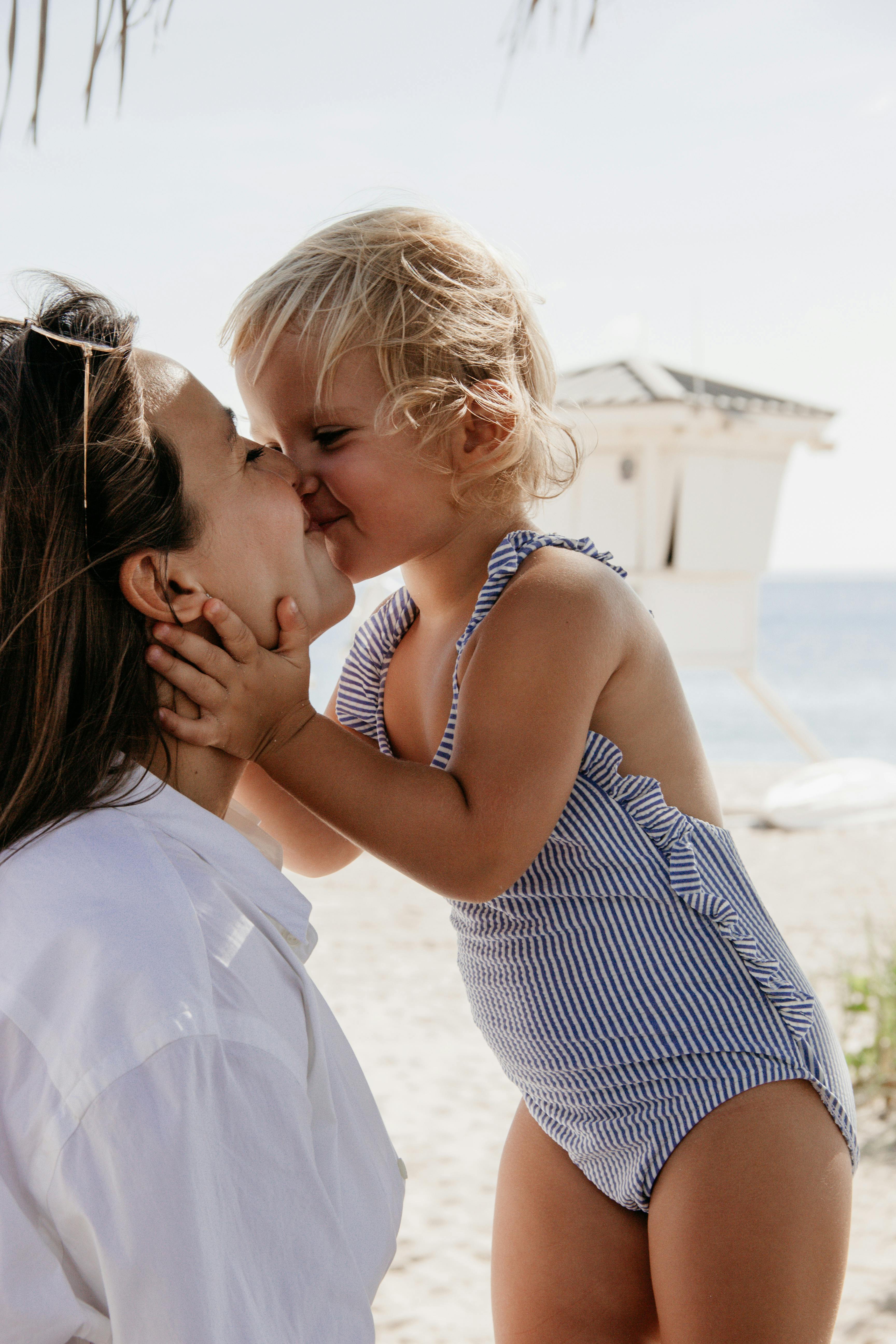 Une mère et une fille heureuses partageant un baiser à la plage | Source : Pexels