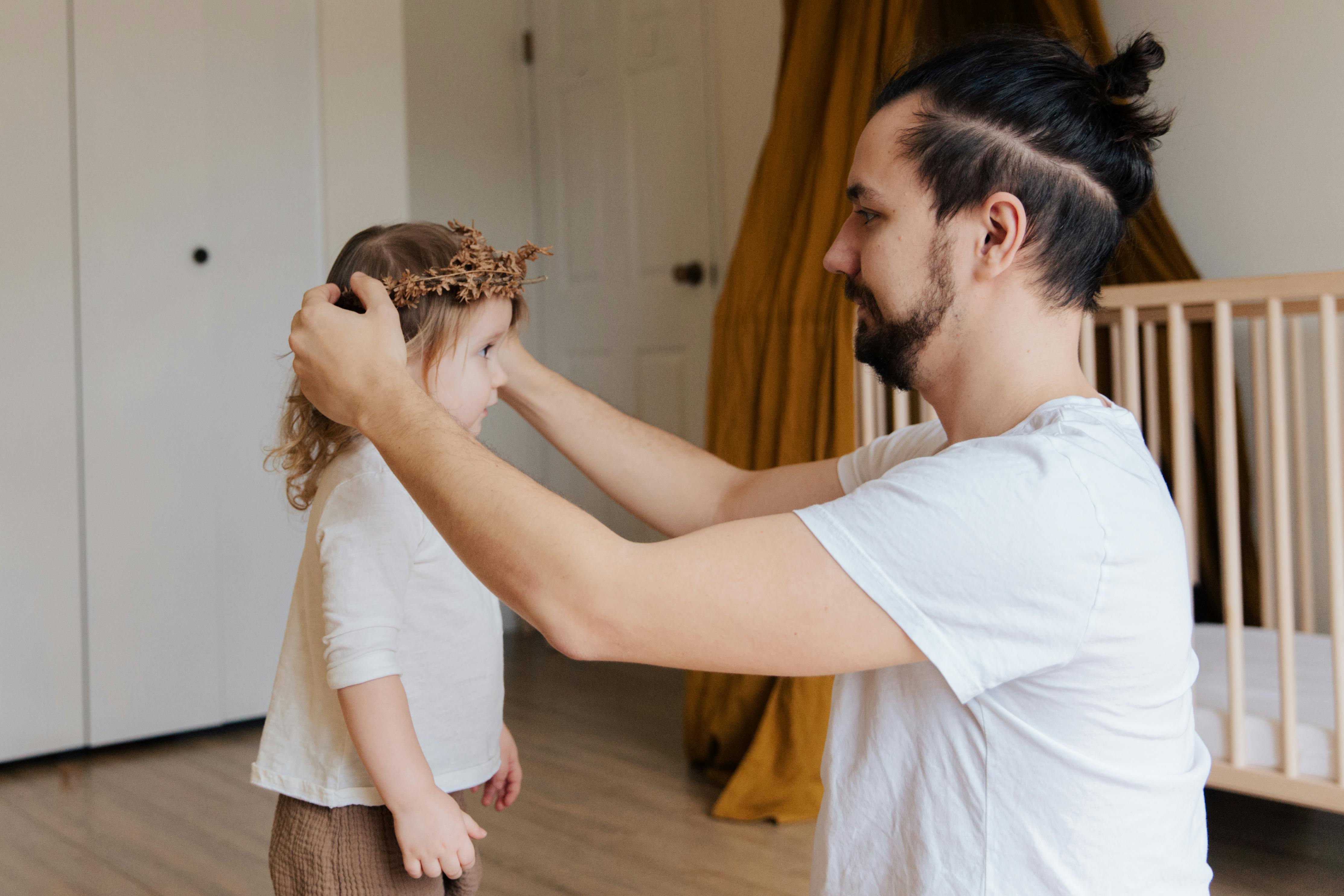 Un père ornant les cheveux de sa fille | Source : Pexels