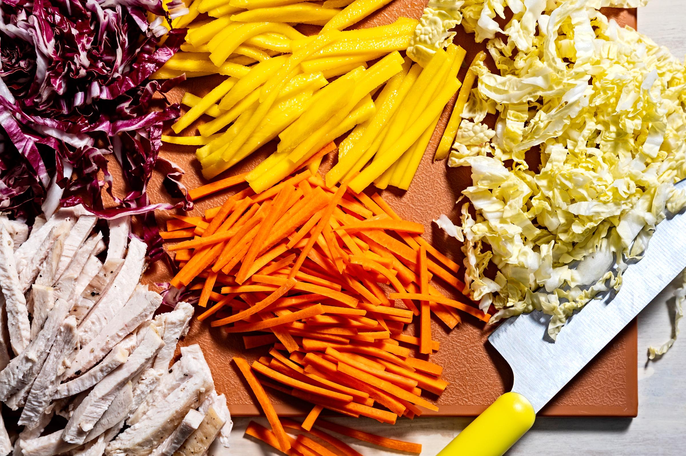 Radicchio, mangue, chou, carottes et poulet coupé en morceaux | Source : Getty Images