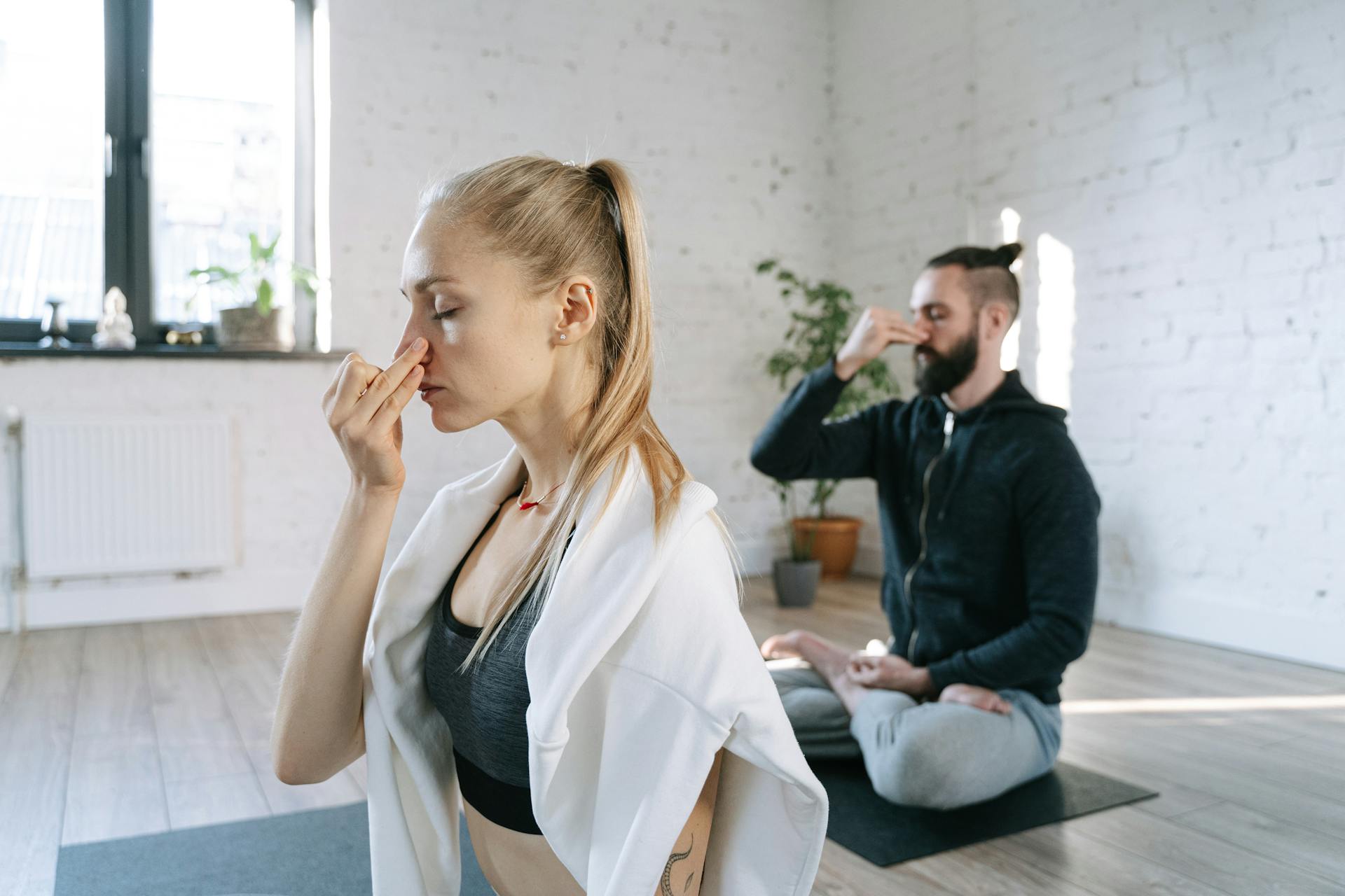 Un couple pratiquant des exercices de respiration lors d'une séance de yoga tranquille | Source : Pexels