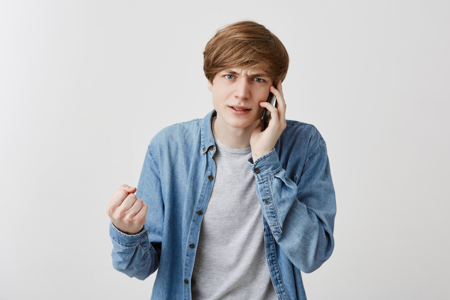 Un jeune homme frénétique qui parle au téléphone | Source : Freepik