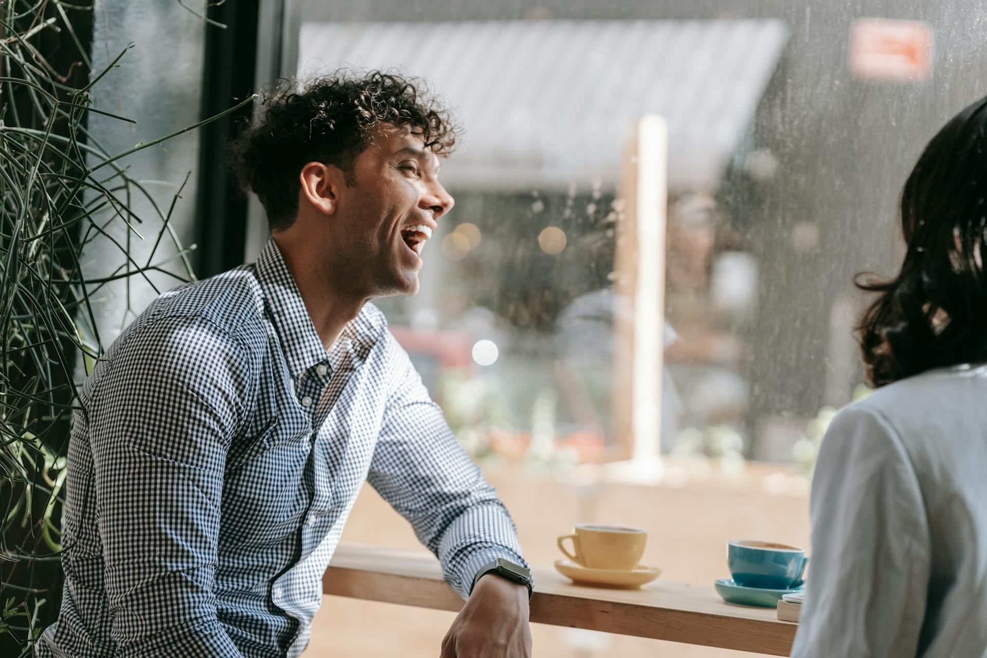 Un homme qui rit dans un café | Source : Pexels