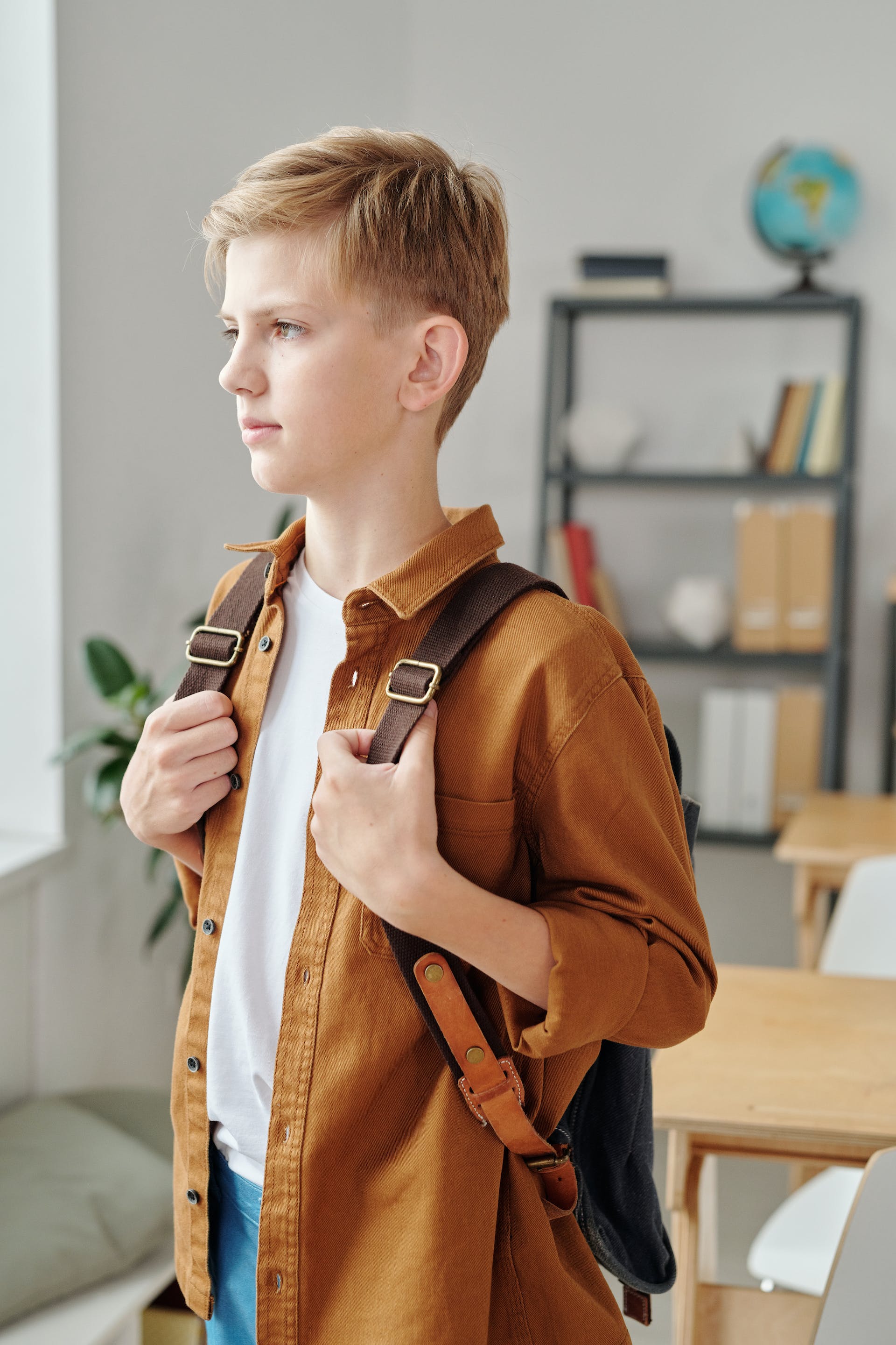 Un jeune garçon triste portant un sac à dos | Source : Pexels