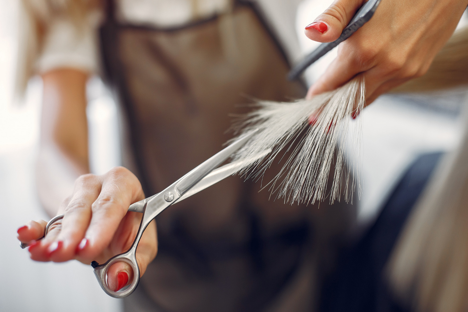 Photo recadrée d'une femme qui coupe les cheveux de quelqu'un | Source : Freepik