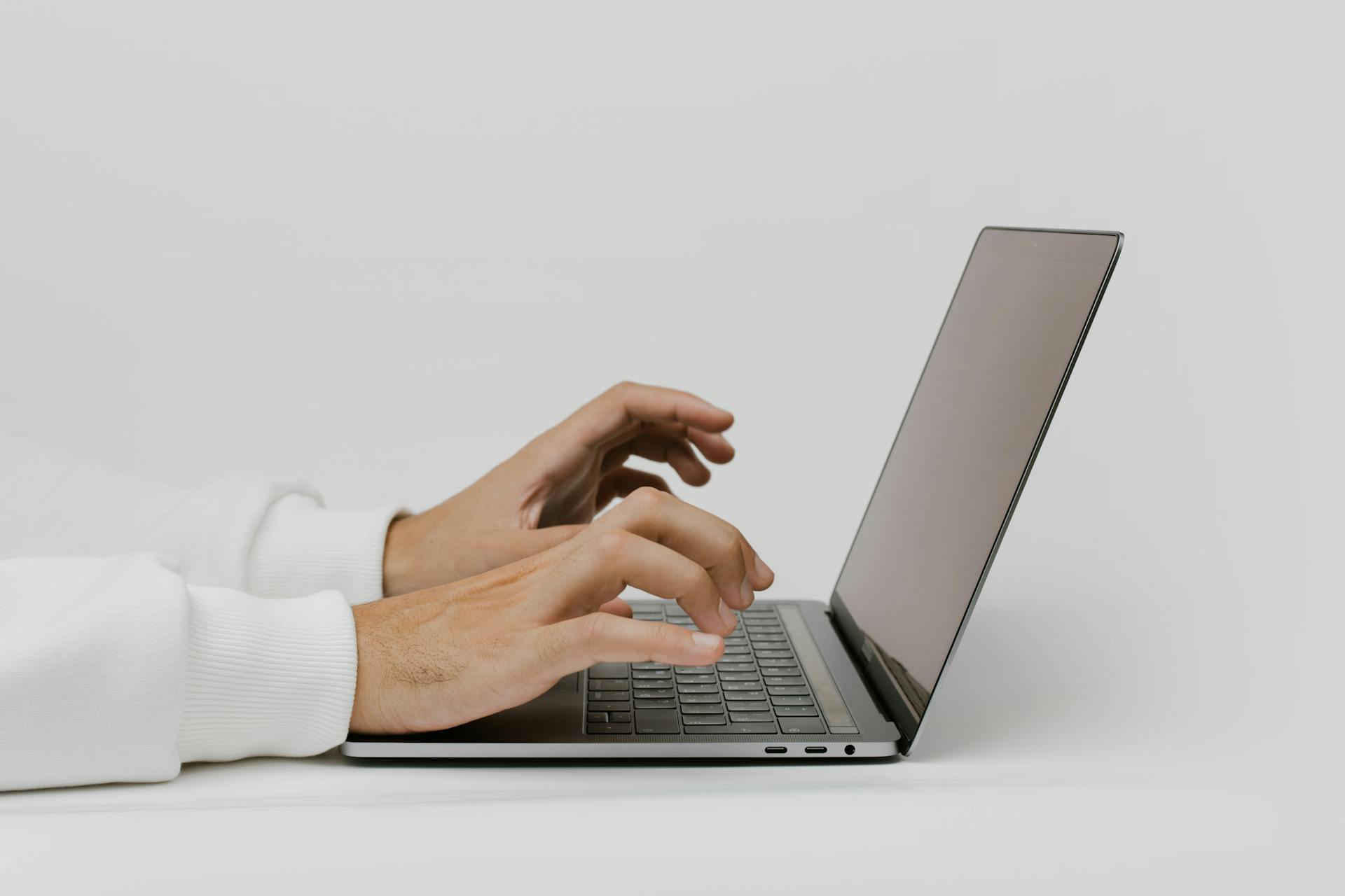 Les mains d'un homme sur un ordinateur portable | Source : Pexels