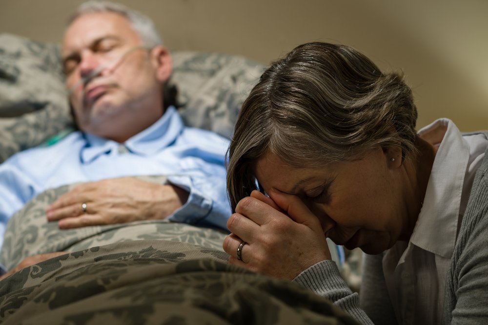 Une vieille femme au chevet de son mari. l Source: Shutterstock